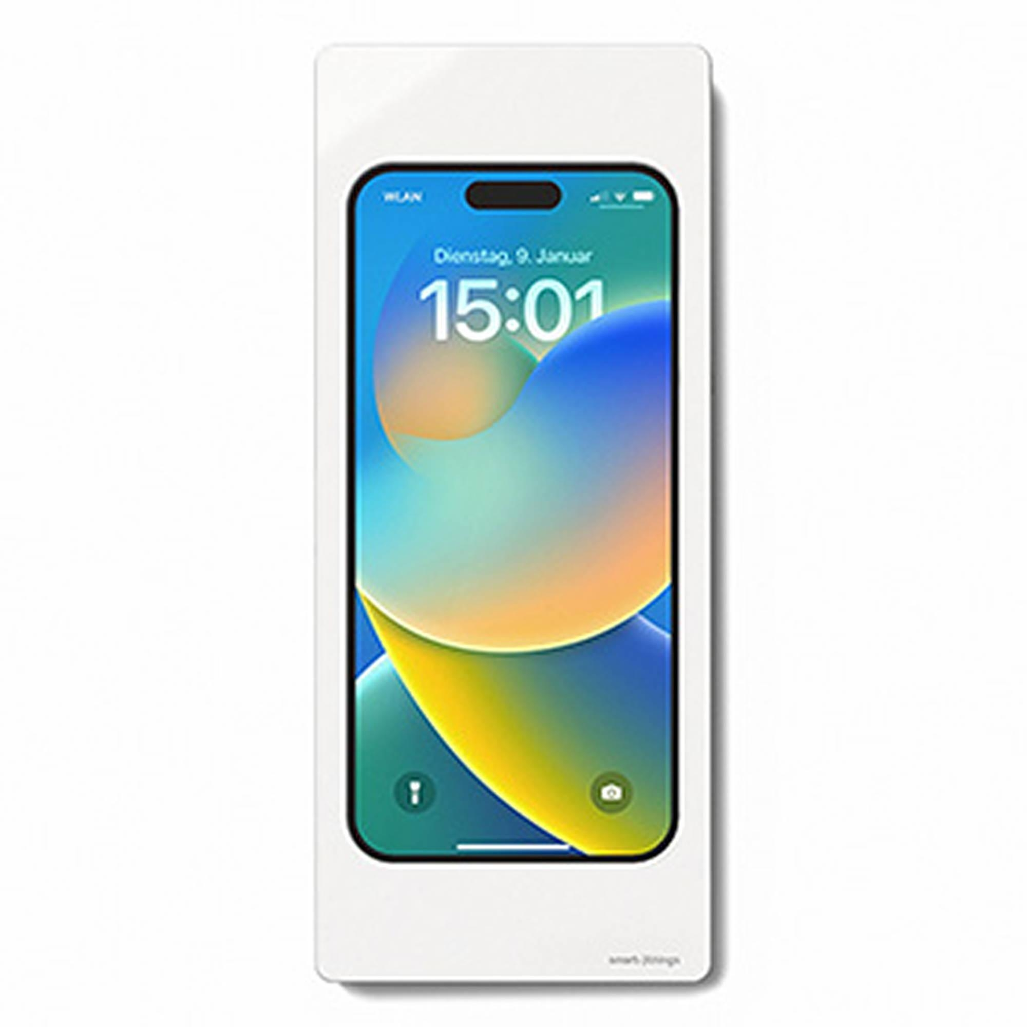 Ein Smartphone mit blau-gelbem Hintergrund und der Uhrzeit 15:01 ist in einen weißen Wandhalter eingelassen.