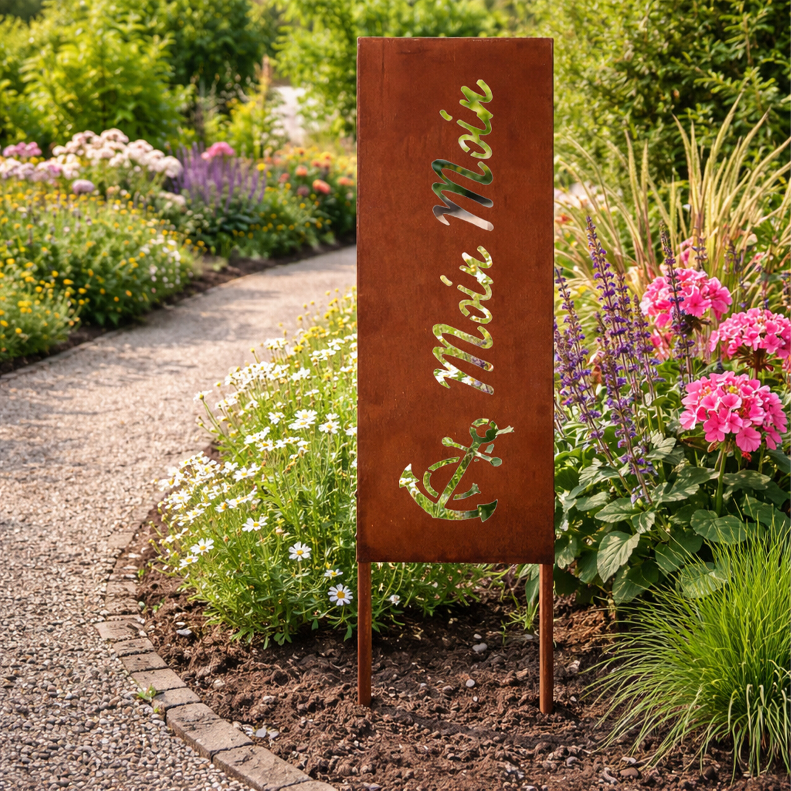 Rostfarbene Gartensäule mit Aufschrift Moin Moin und Anker in einem blühenden Garten.