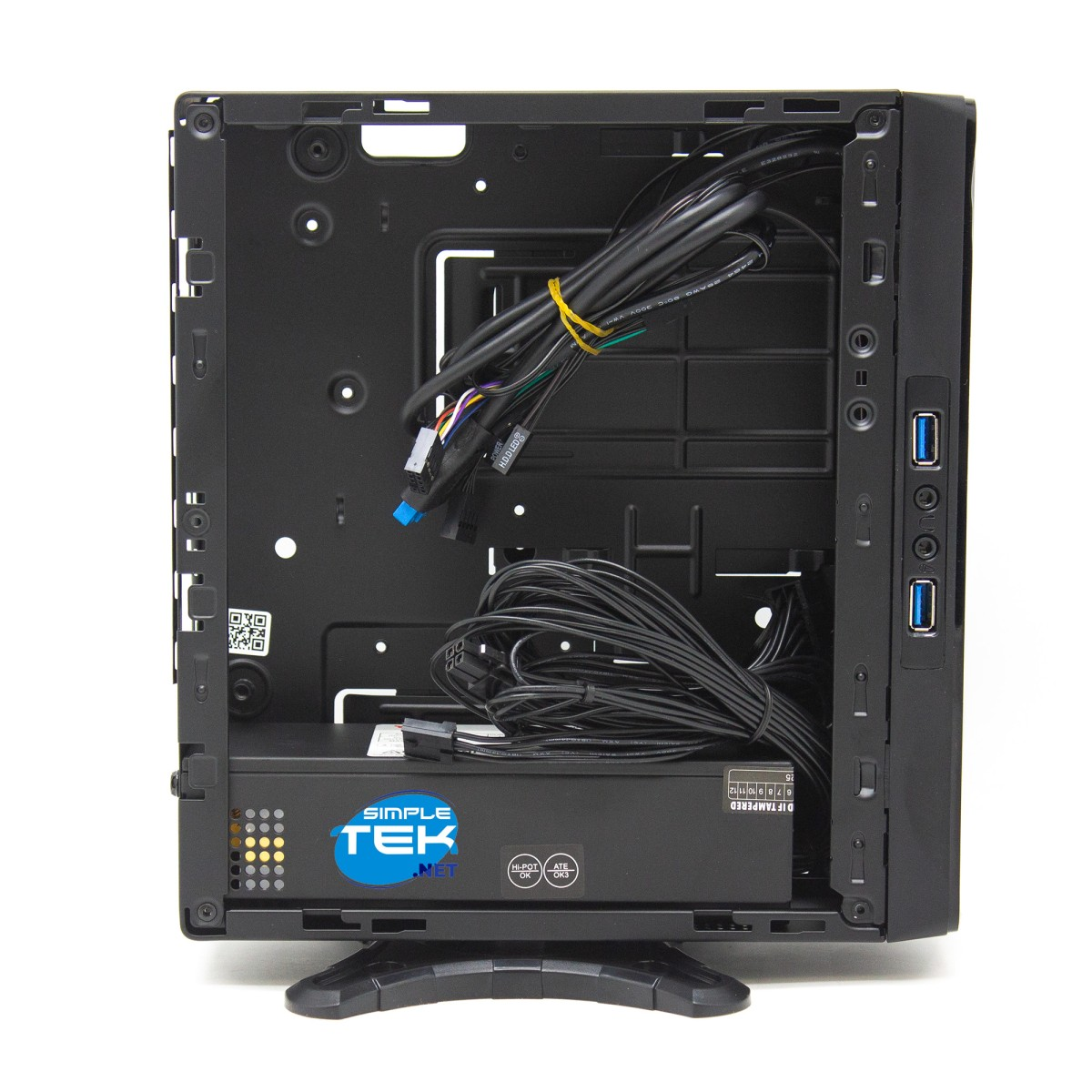 Vista interna di un mini case per PC nero con alimentatore, cavi raggruppati e logo Simple Tek su sfondo bianco.