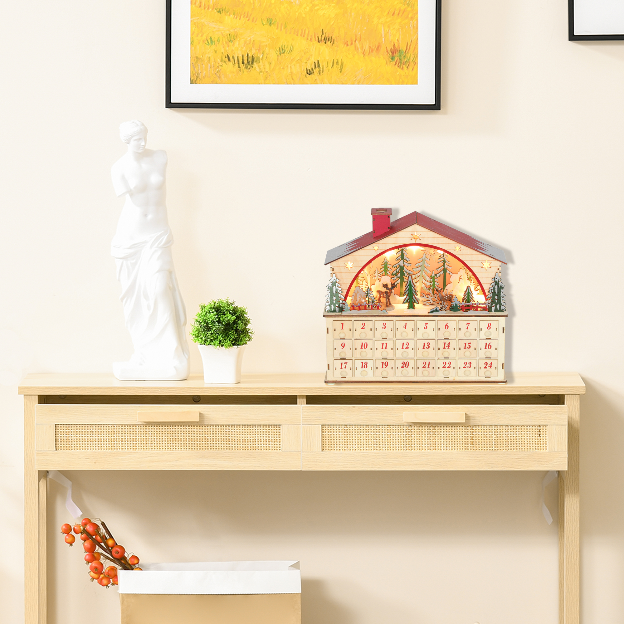 Una casa de calendario de adviento de madera con una escena invernal iluminada está en una mesa consola.