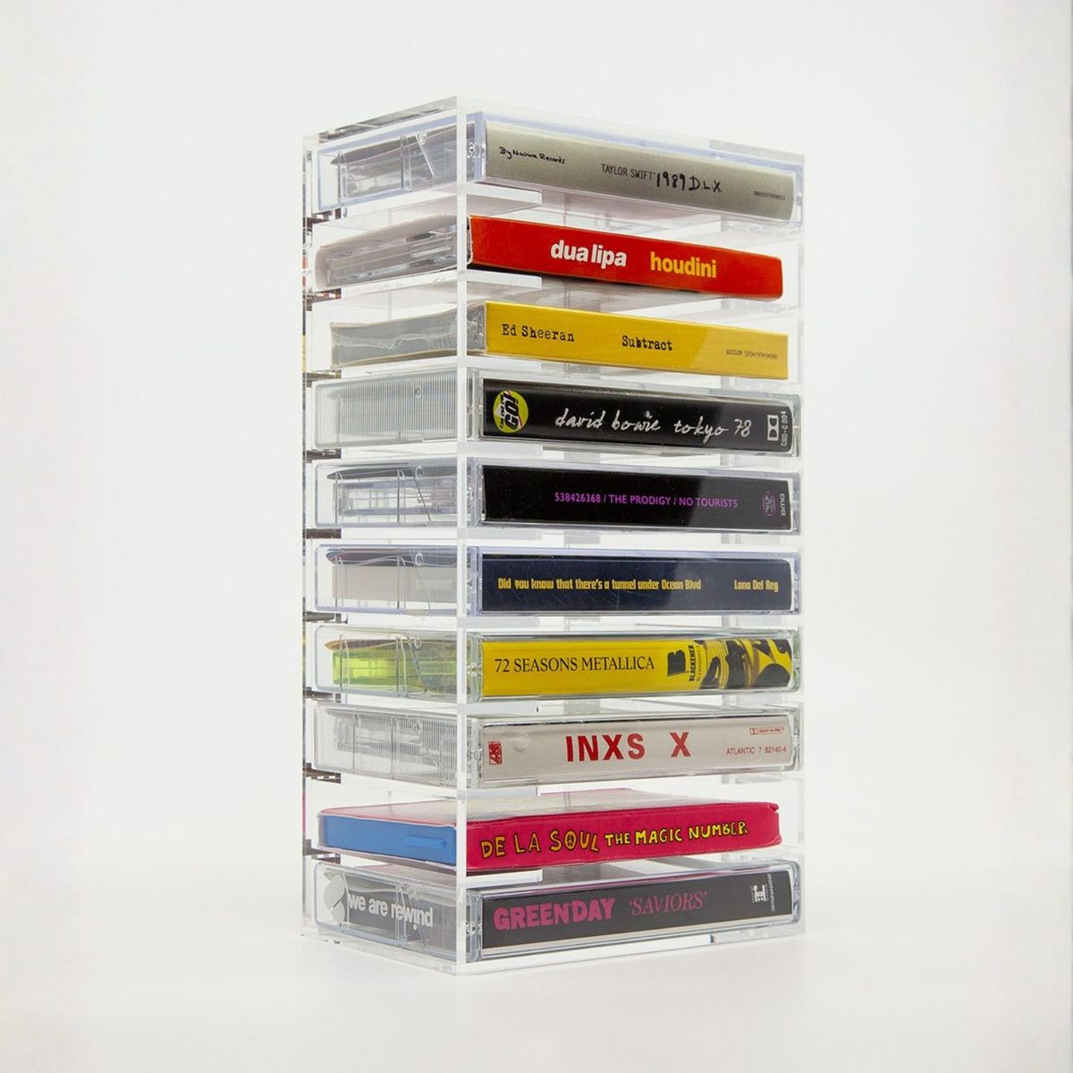 Ein klarer Acrylständer enthält zehn bunte MusikKassetten auf weißem Hintergrund.