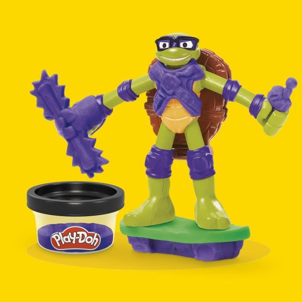 Donatello Teenage Mutant Ninja Turtle Actionfigur mit lila Maske und Waffe neben einem Play-Doh-Becher.