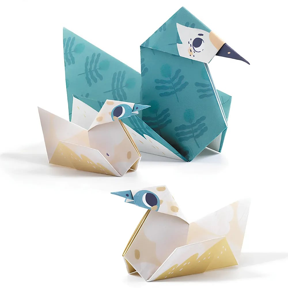 Drei gefaltete Papierhühner in Türkis und Creme mit Blattmustern und gedruckten Augen auf weißem Hintergrund.