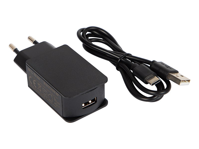 Caricabatterie da muro nero con porta USB e cavo nero da USB-A a USB-C arrotolato su sfondo bianco.