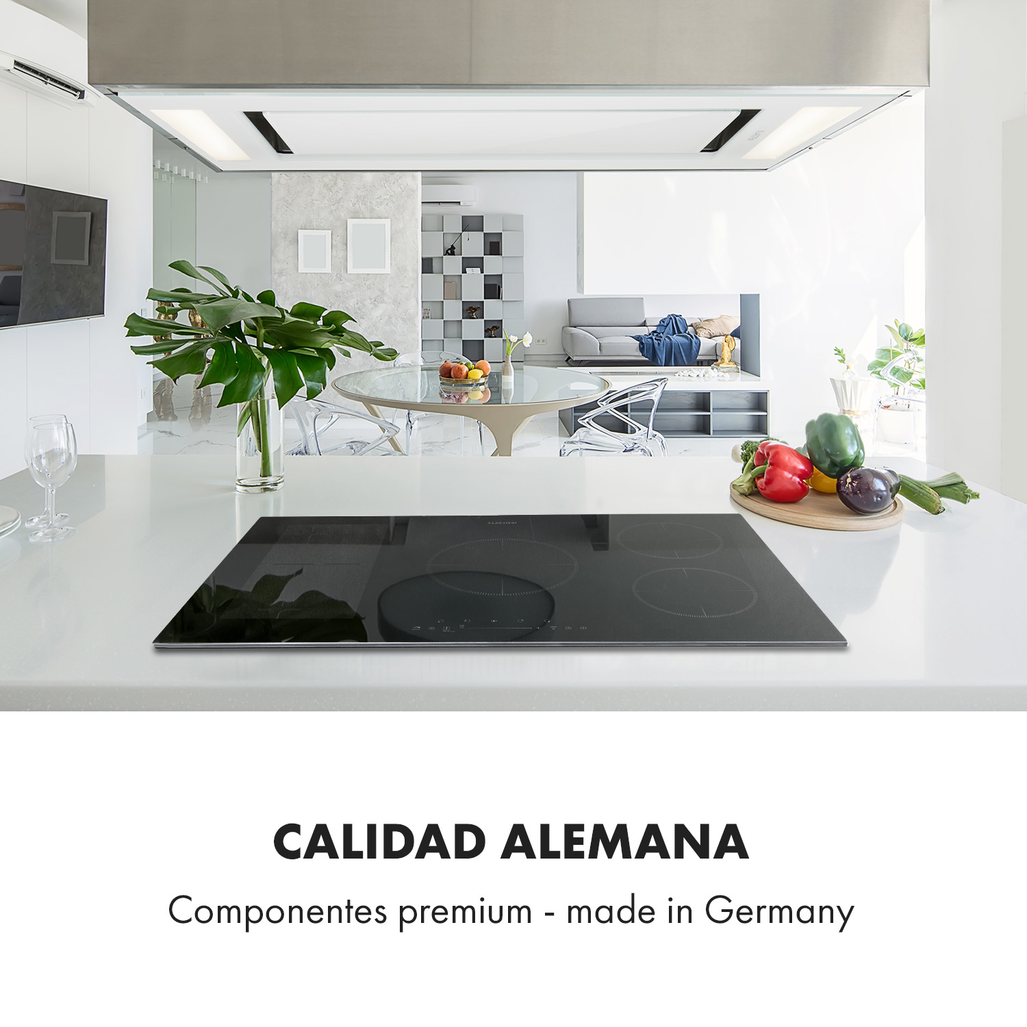 Un piano cottura a induzione nero su un'isola cucina bianca, con verdure fresche e un soggiorno moderno sullo sfondo.