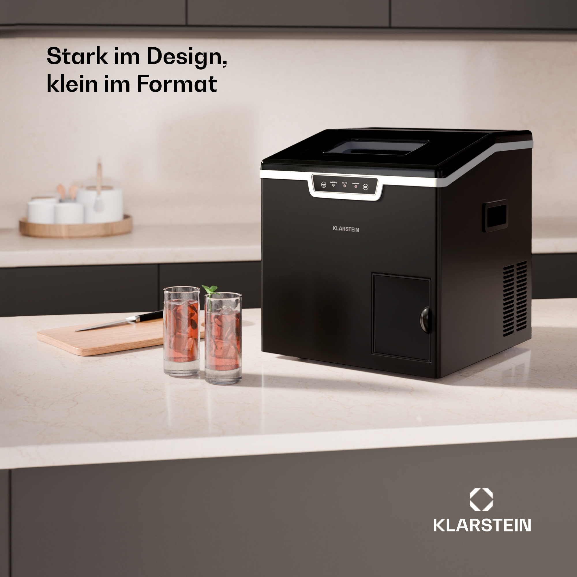 Eine schwarze Klarstein Eismaschine steht neben zwei Gläsern mit Kaltgetränk und einem Schneidebrett auf einer Theke.