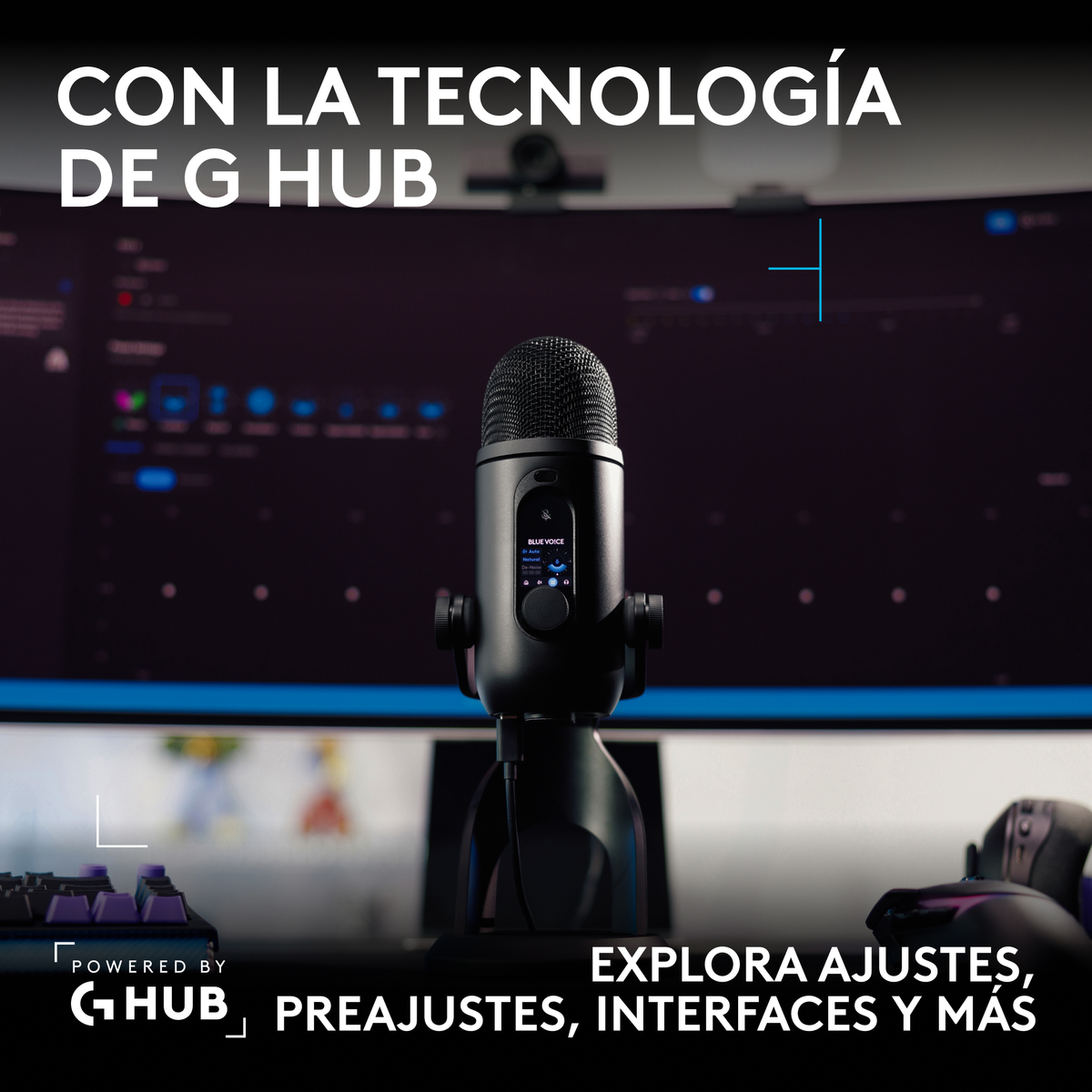 Un micrófono negro en un escritorio frente a un monitor con texto en español.