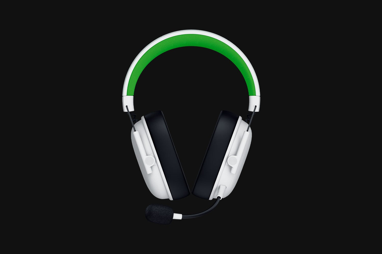 Auriculares para juegos blancos y negros con diadema verde y micrófono sobre fondo negro.