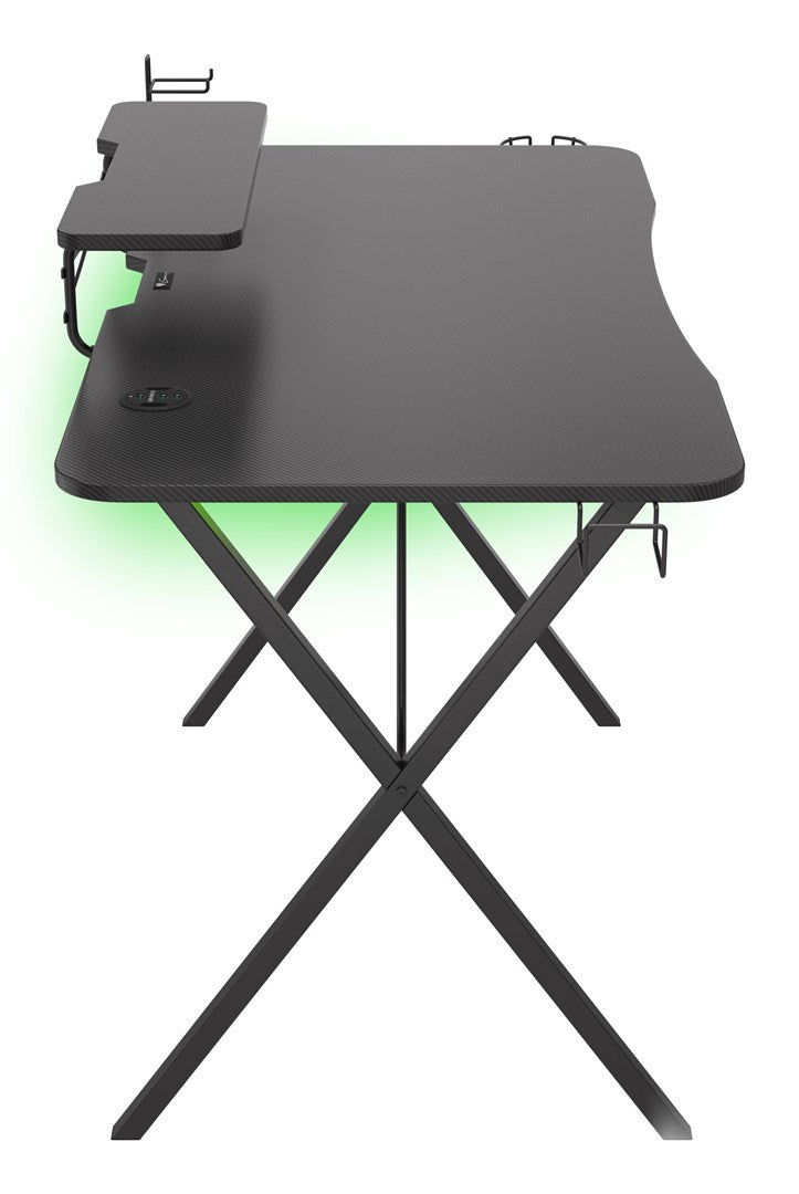 Un escritorio negro para juegos con patas metálicas en forma de X y retroiluminación LED verde sobre fondo blanco.