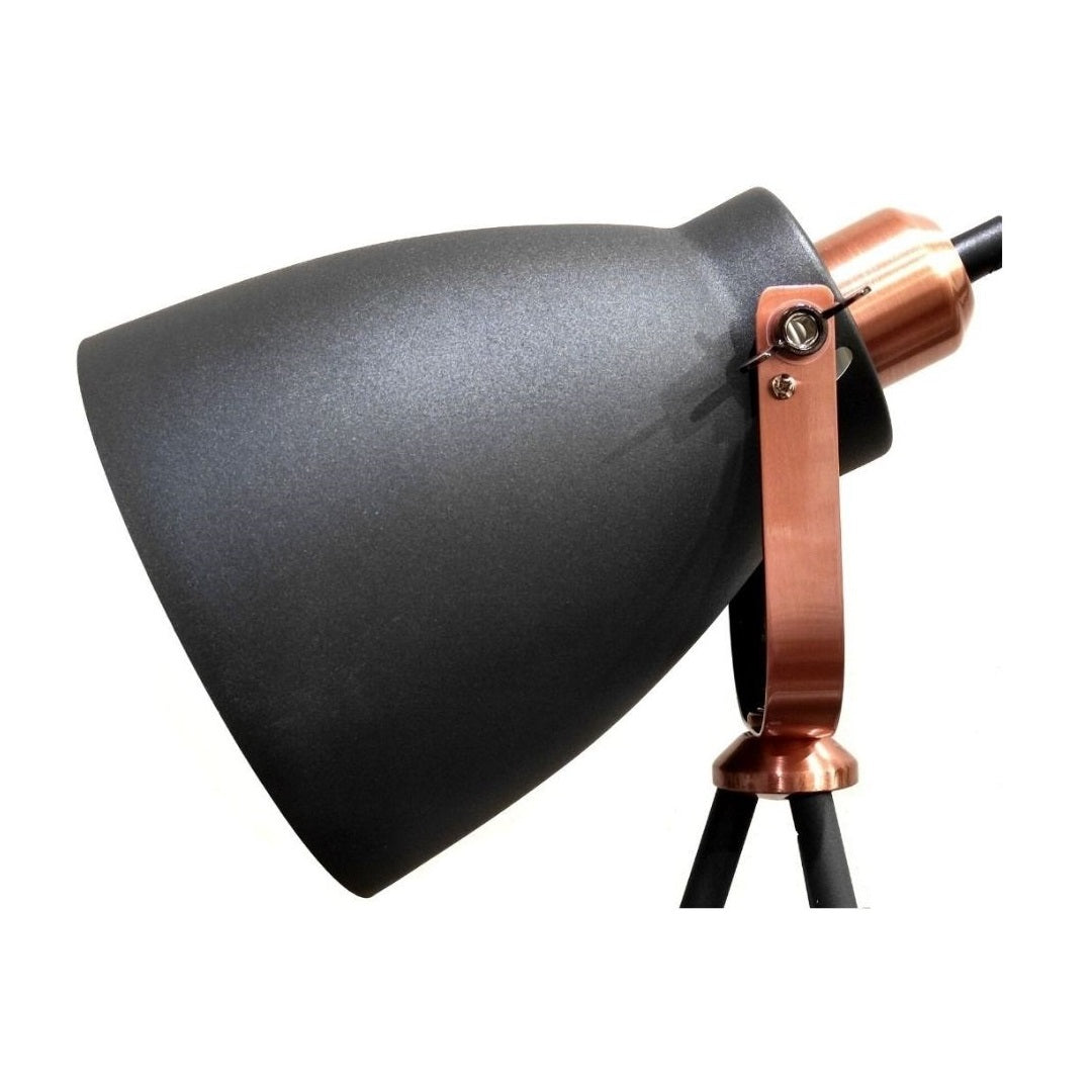 Un flexo negro con detalles en cobre y bisagra ajustable sobre fondo blanco.