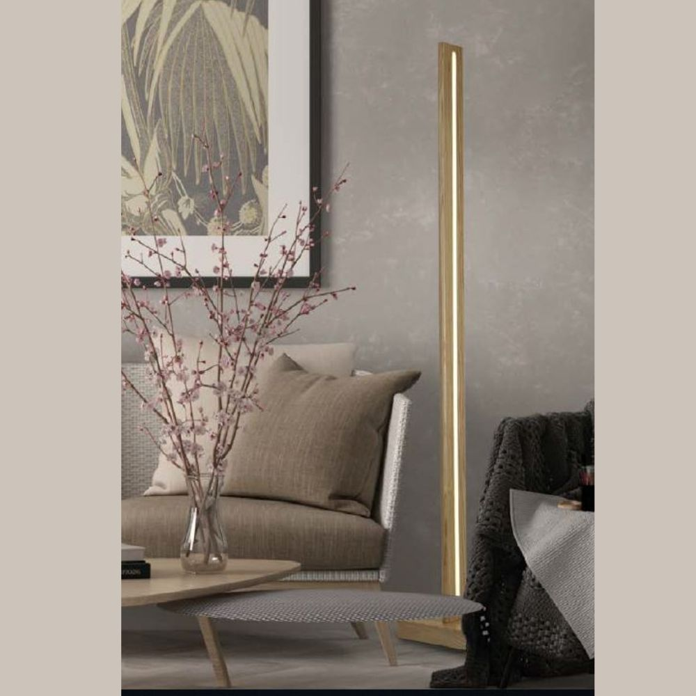 Lámpara de pilar de madera moderna en una sala de estar elegante con cojines, flores y arte.