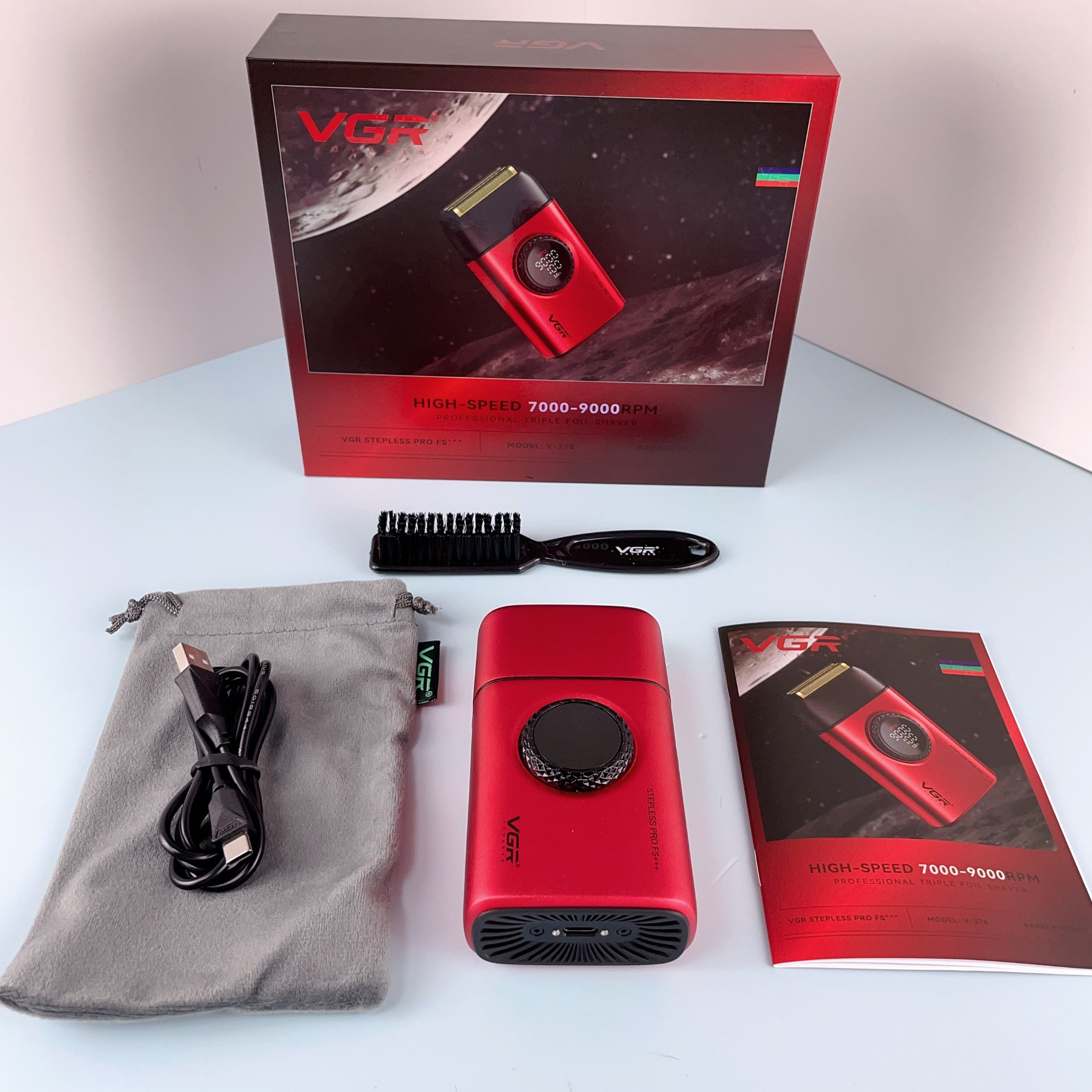 Kutu, kese, USB kablosu, fırça ve kılavuz dahil aksesuarlarıyla birlikte kırmızı tıraş makinesi.