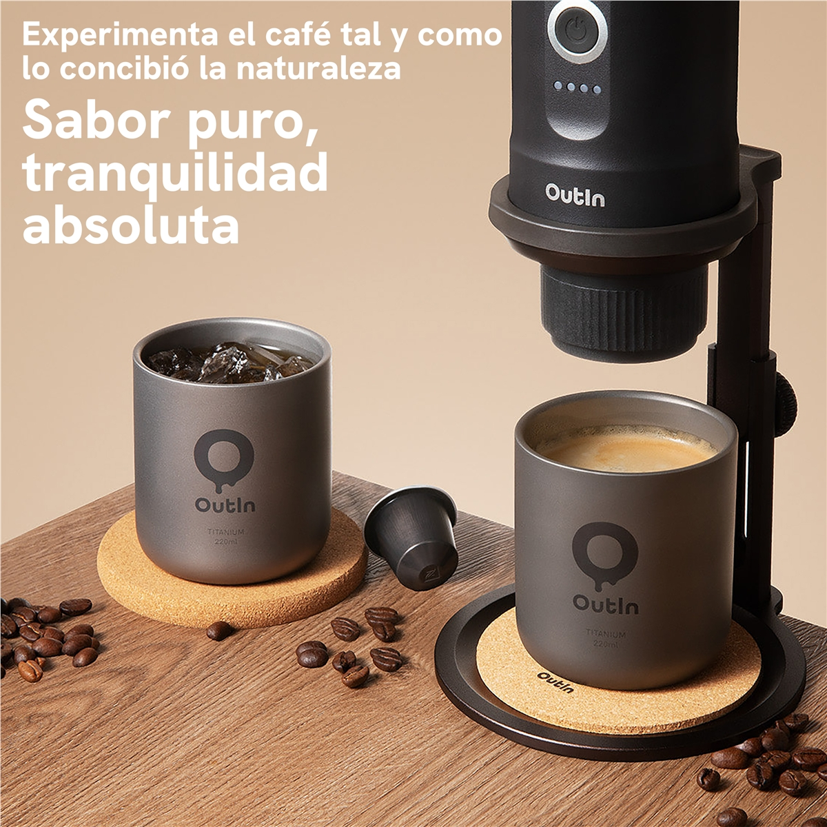 Cafetera OutIn y dos tazas OutIn con café en una mesa de madera con granos de café.