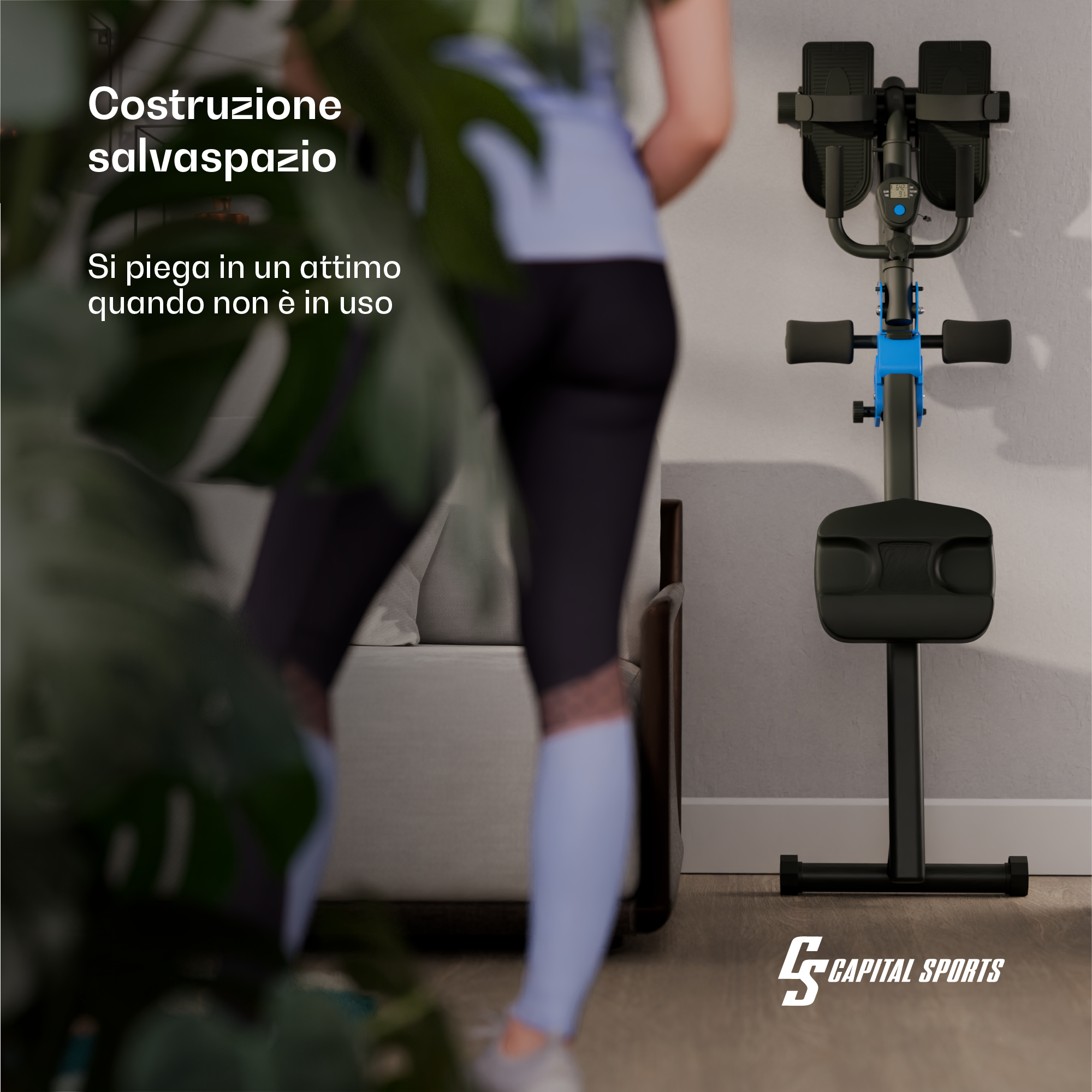 Eine Person steht in einem Wohnzimmer neben einem zusammenklappbaren Trainingsgerät.