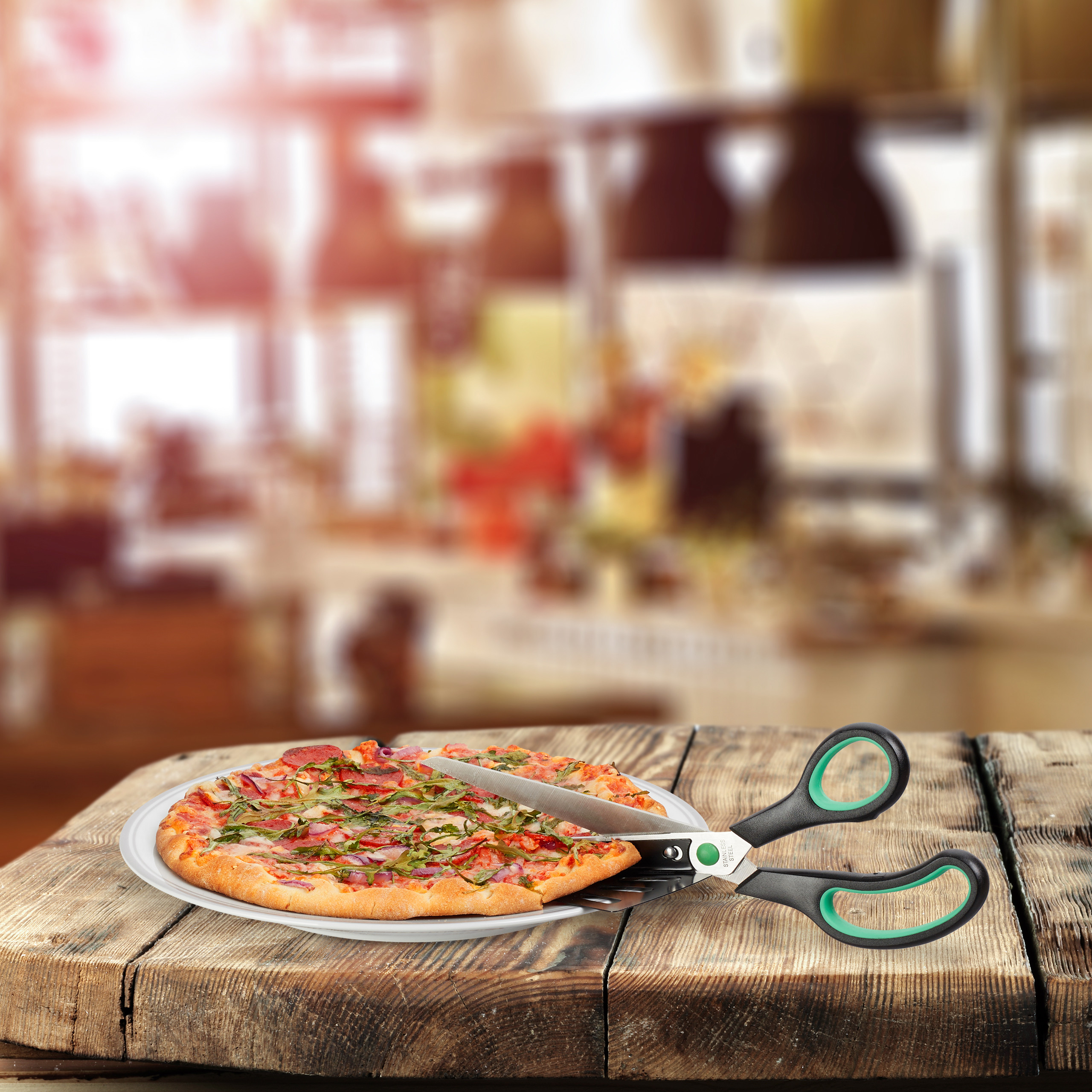 Eine Pizza auf einem Teller mit Pizzaschere auf einem Holztisch vor verschwommenem Hintergrund.