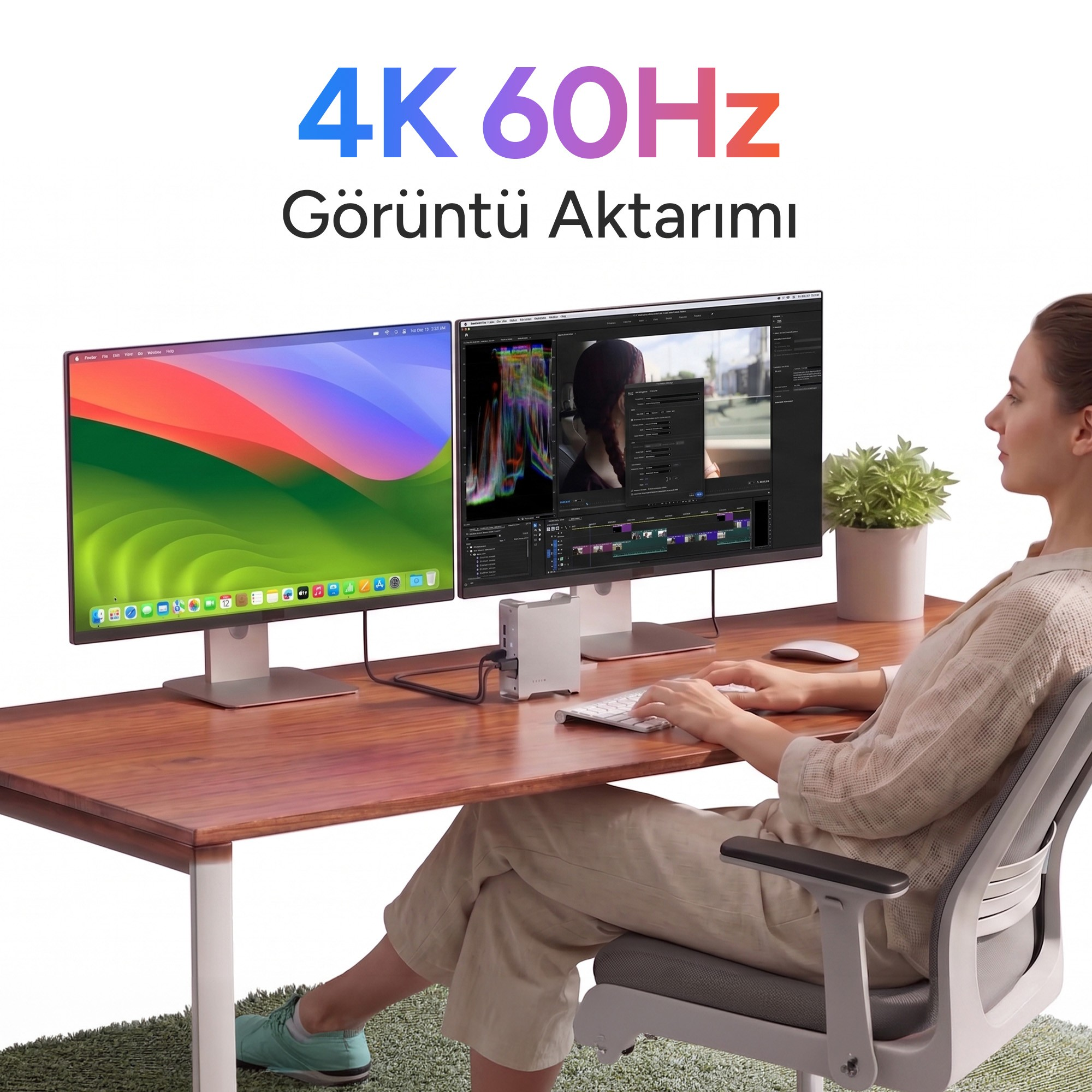 Bir kadın, kompakt bir istasyona bağlı iki monitörlü ahşap bir masada çalışıyor.