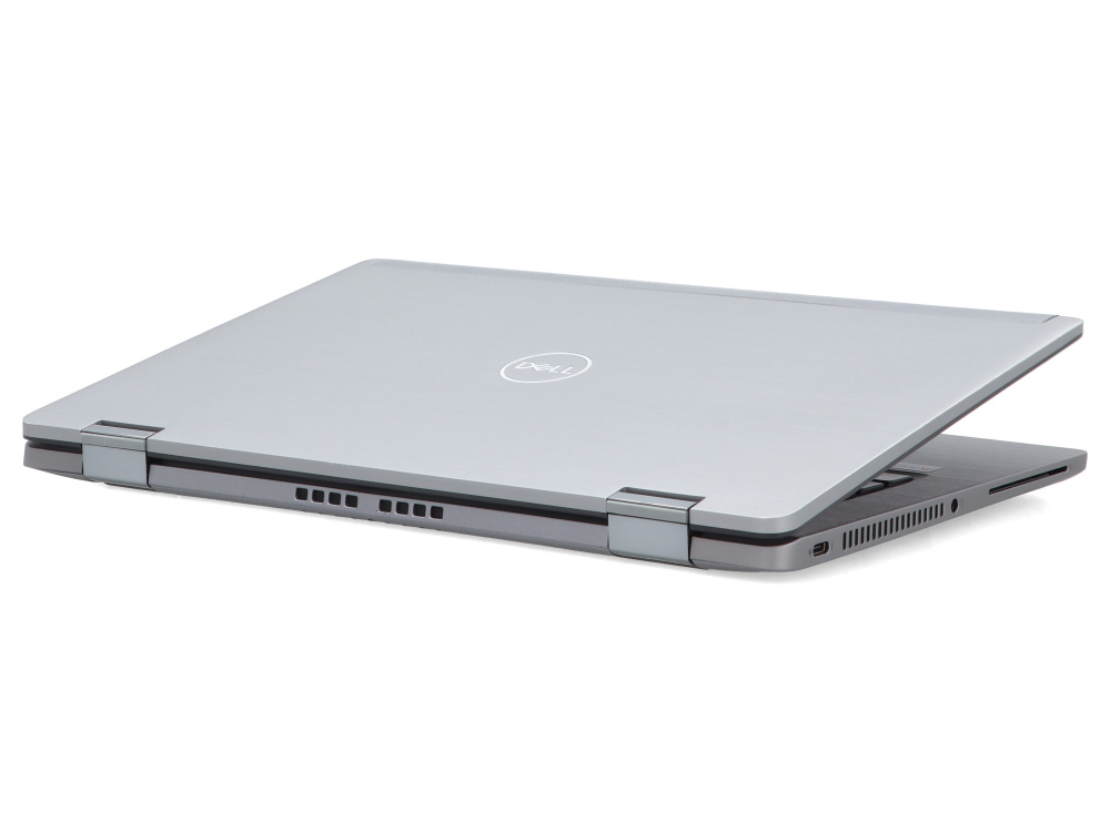 Srebrny laptop Dell jest pokazany lekko otwarty na białej powierzchni.