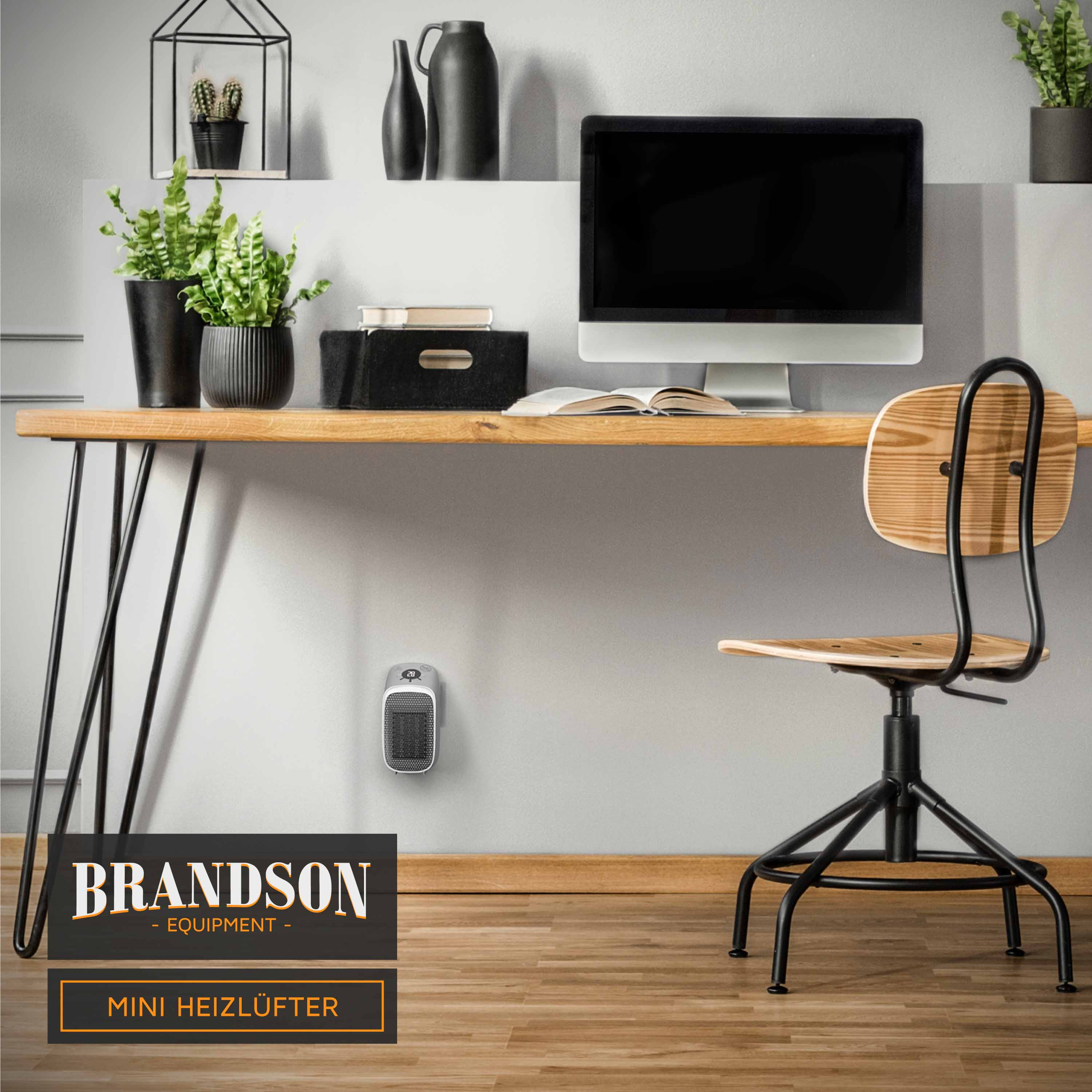 Ein modernes Schreibtisch-Setup mit Computer, Pflanzen, Büchern und einem kleinen Heizlüfter an der Wand.