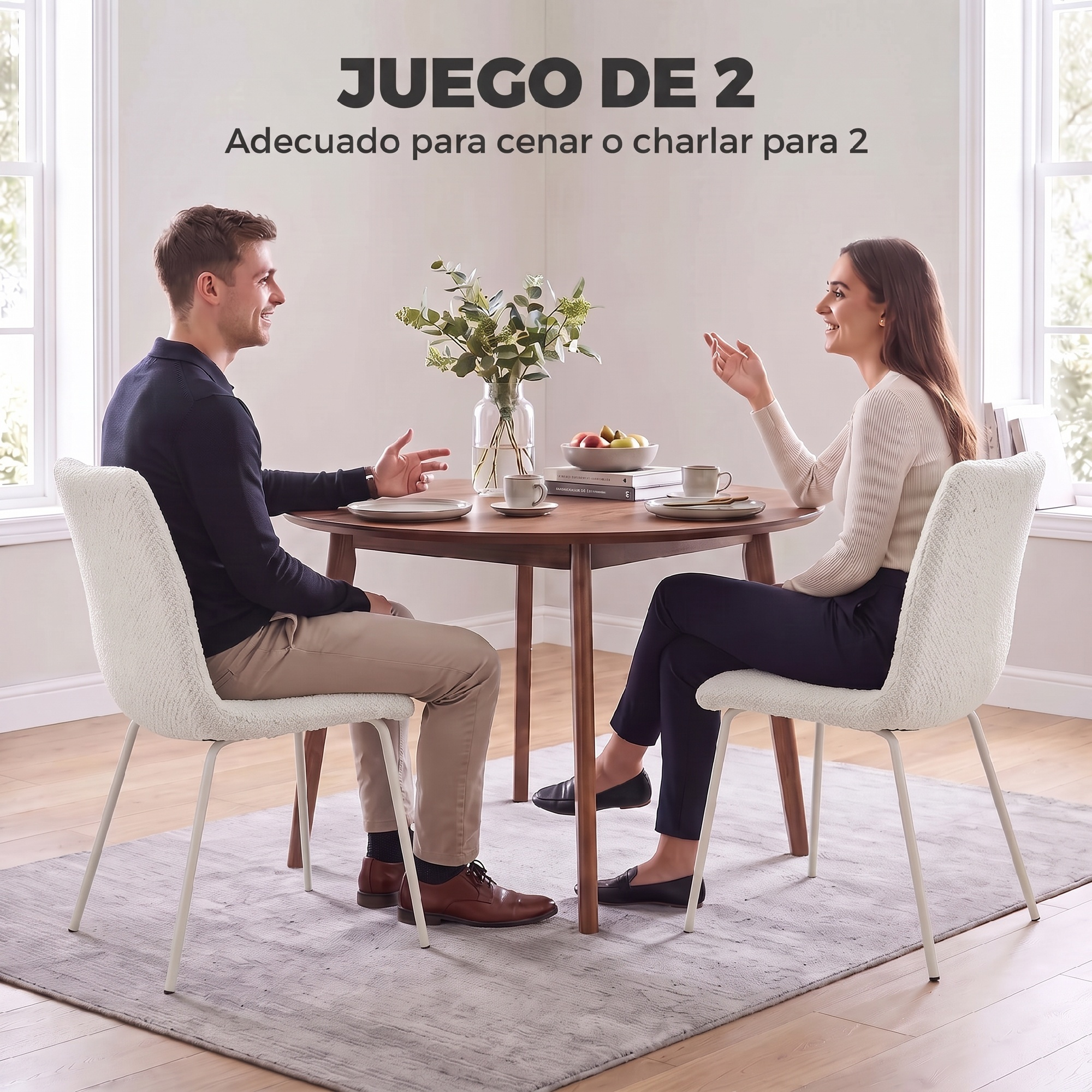 Un hombre y una mujer se sientan a una mesa de comedor de madera redonda, hablando y sonriendo.