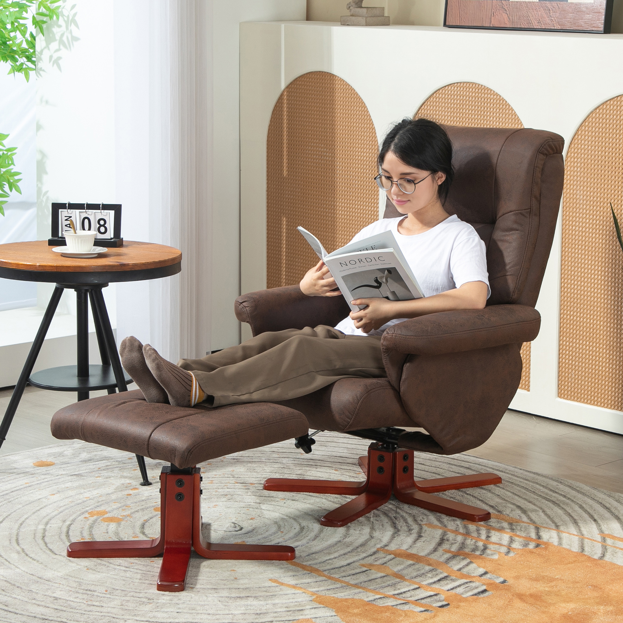 Una mujer lee un libro en un sillón de cuero marrón con reposapiés en una habitación luminosa.
