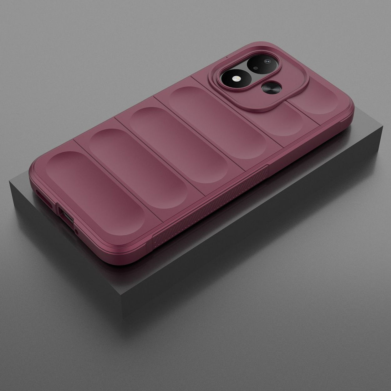 A maroon phone case with a quilted, pillared design on a grey stand.