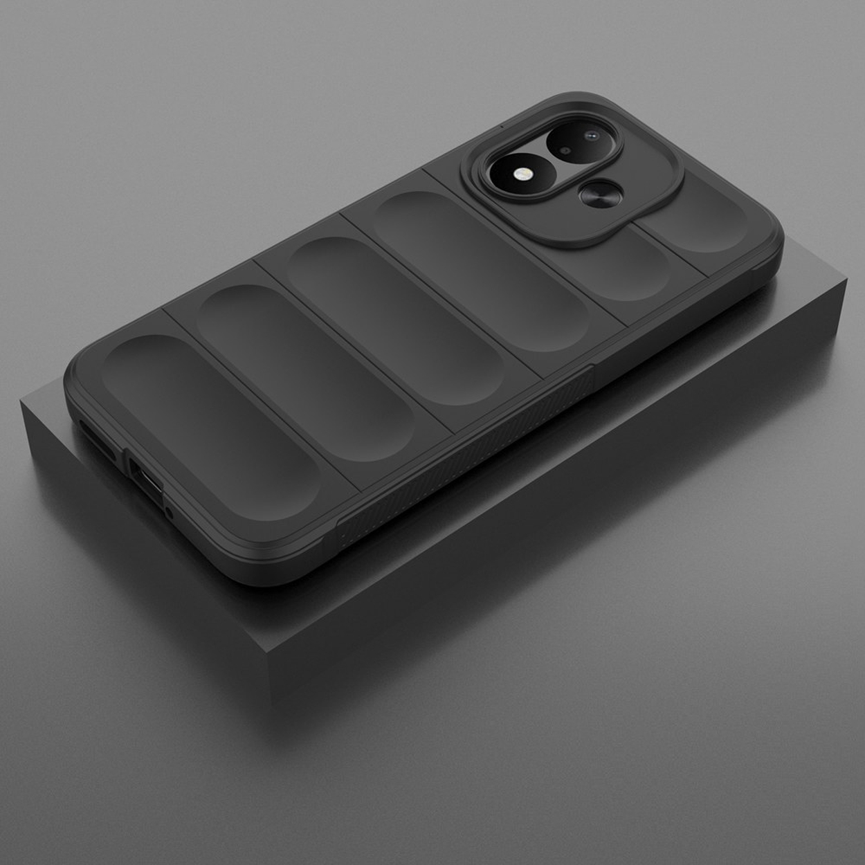 A black smartphone with a textured protective case and dual camera rests on a gray pedestal.