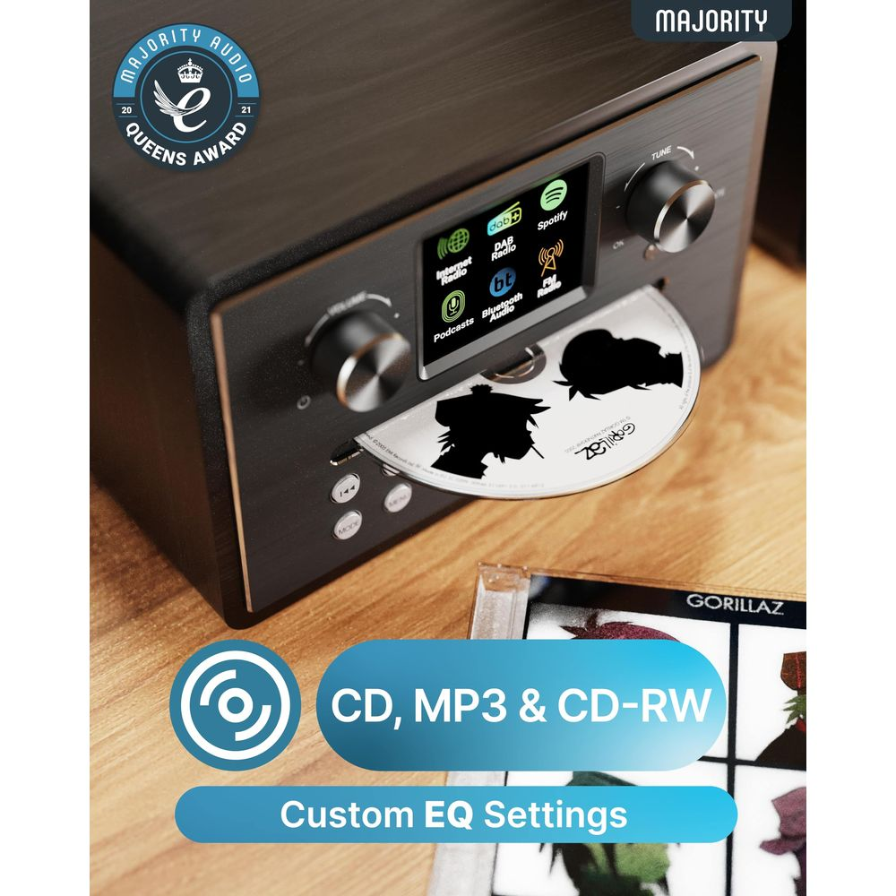 Ein schwarzes Majority-Audiosystem auf Holz mit eingelegter CD, digitalem Bildschirm und einer Gorillaz-CD-Hülle.