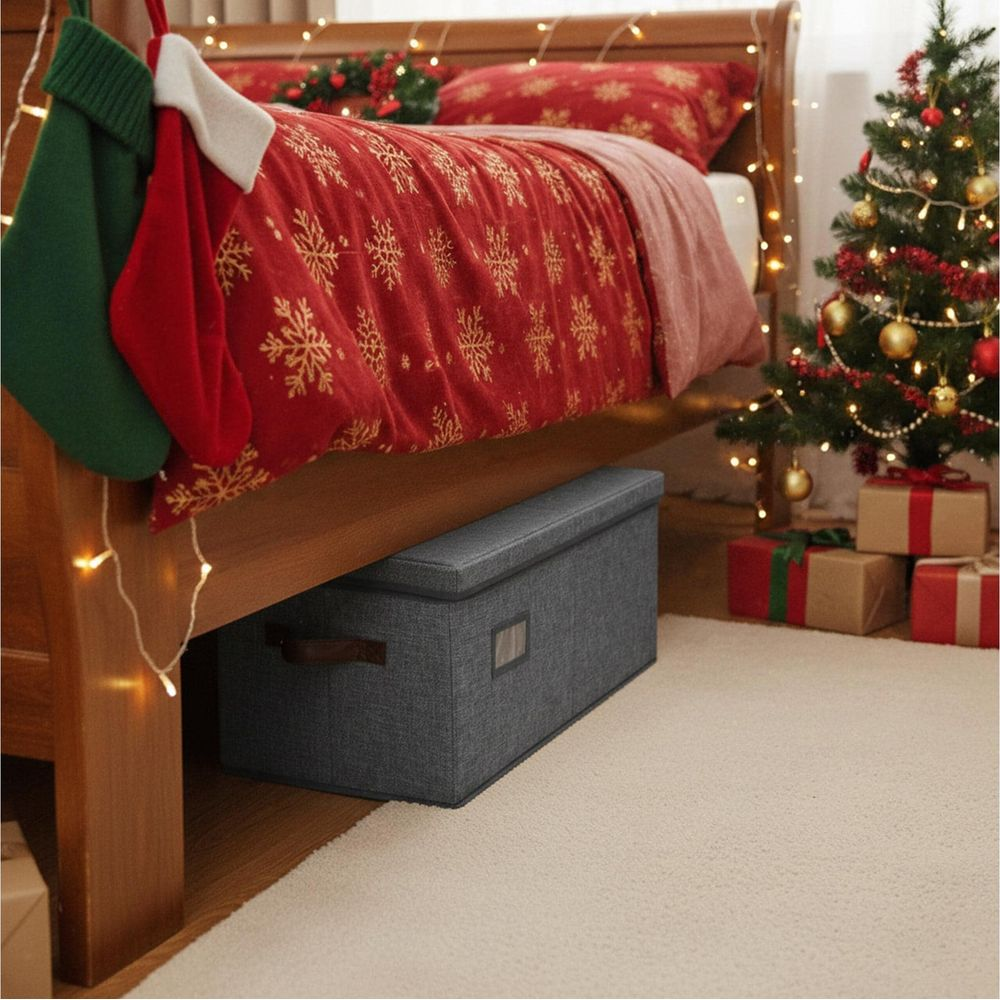 Eine graue Aufbewahrungsbox unter dem Bett steht auf einem hellen Teppich in einem weihnachtlich geschmückten Schlafzimmer.