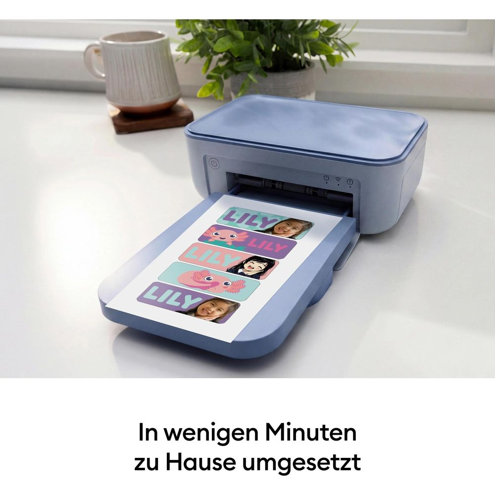 Una mini impresora azul claro imprime una hoja de pegatinas personalizadas con nombres y caras.