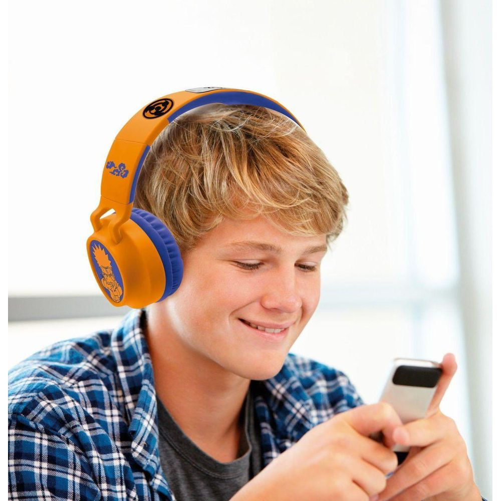Ein blondhaariger Junge mit blau-orangen Kopfhörern lächelt und hält ein Smartphone in den Händen.