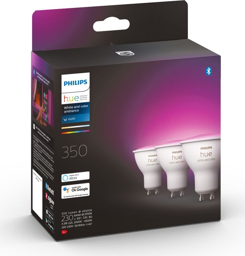 Verpackung von drei Philips Hue GU10 White and Color Ambiance LED-Lampen vor dunklem Hintergrund.
