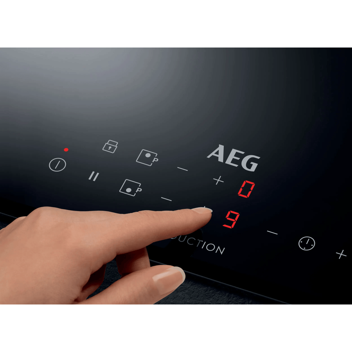 Mano operando una placa de inducción AEG negra con números LED rojos.