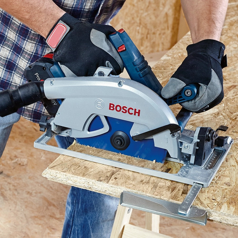 A person uses a blue and silver Bosch circular saw to cut a wooden board.