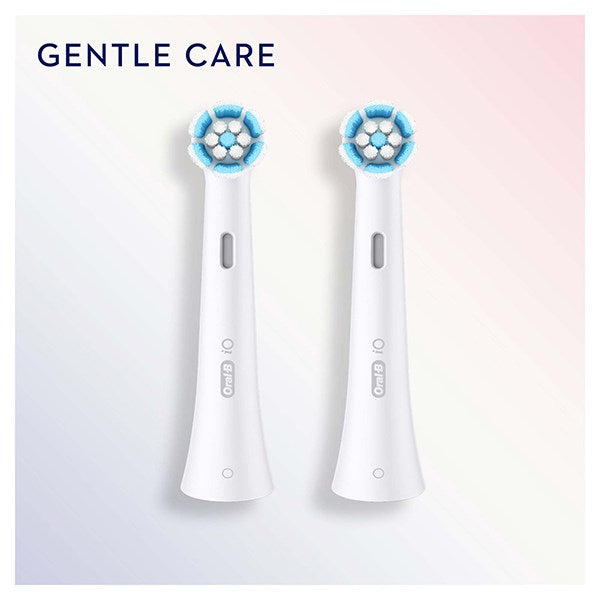 Due testine di ricambio bianche per spazzolino Oral-B iO Gentle Care su sfondo rosa e blu chiaro.