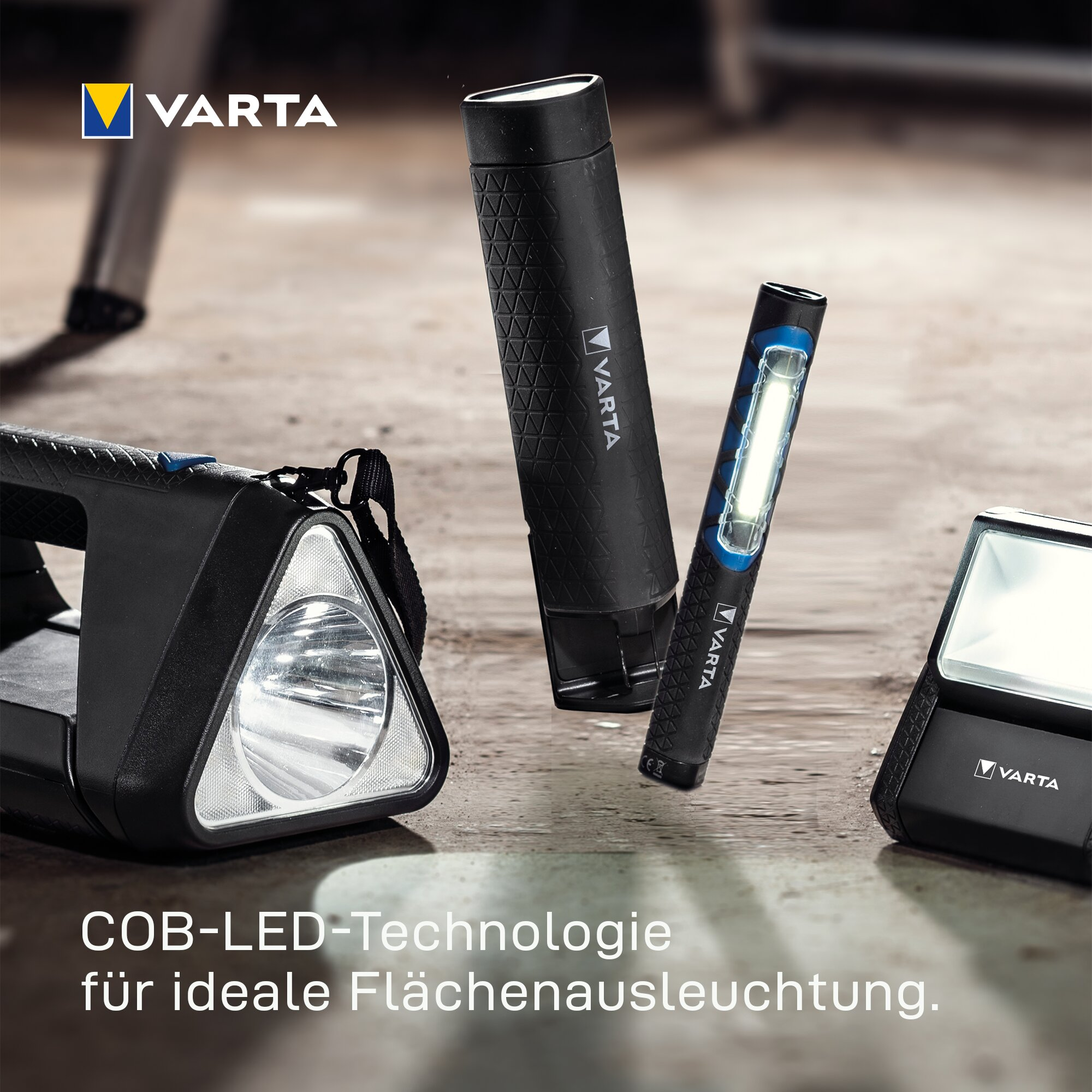 Cuatro linternas LED y luces de trabajo Varta sobre una mesa de madera con texto.