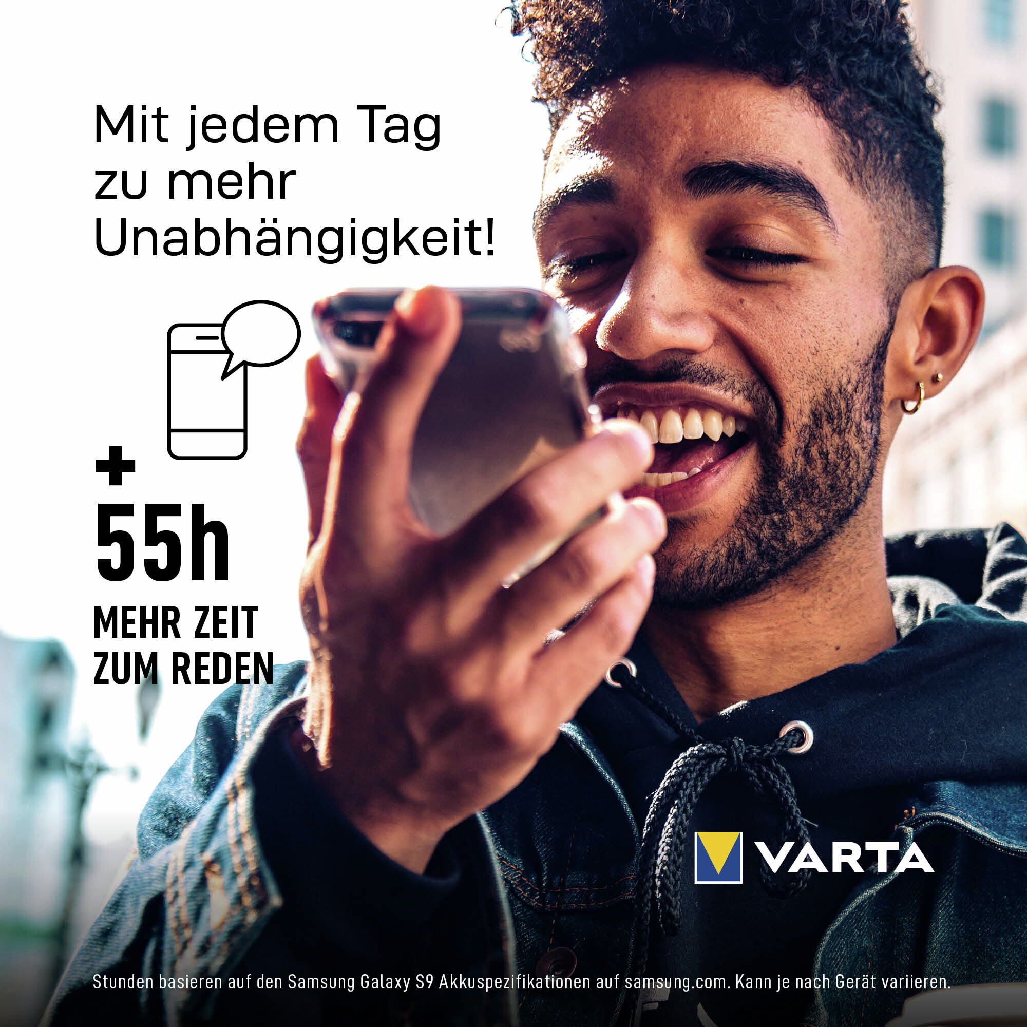 Lächeln der Mann hält ein Smartphone im Freien mit deutschem Werbetext und Varta-Logo.