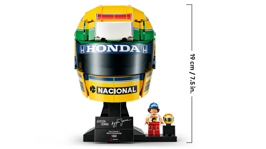 Model kasku Lego Ayrton Senna ze stojakiem i minifigurką na białym tle.
