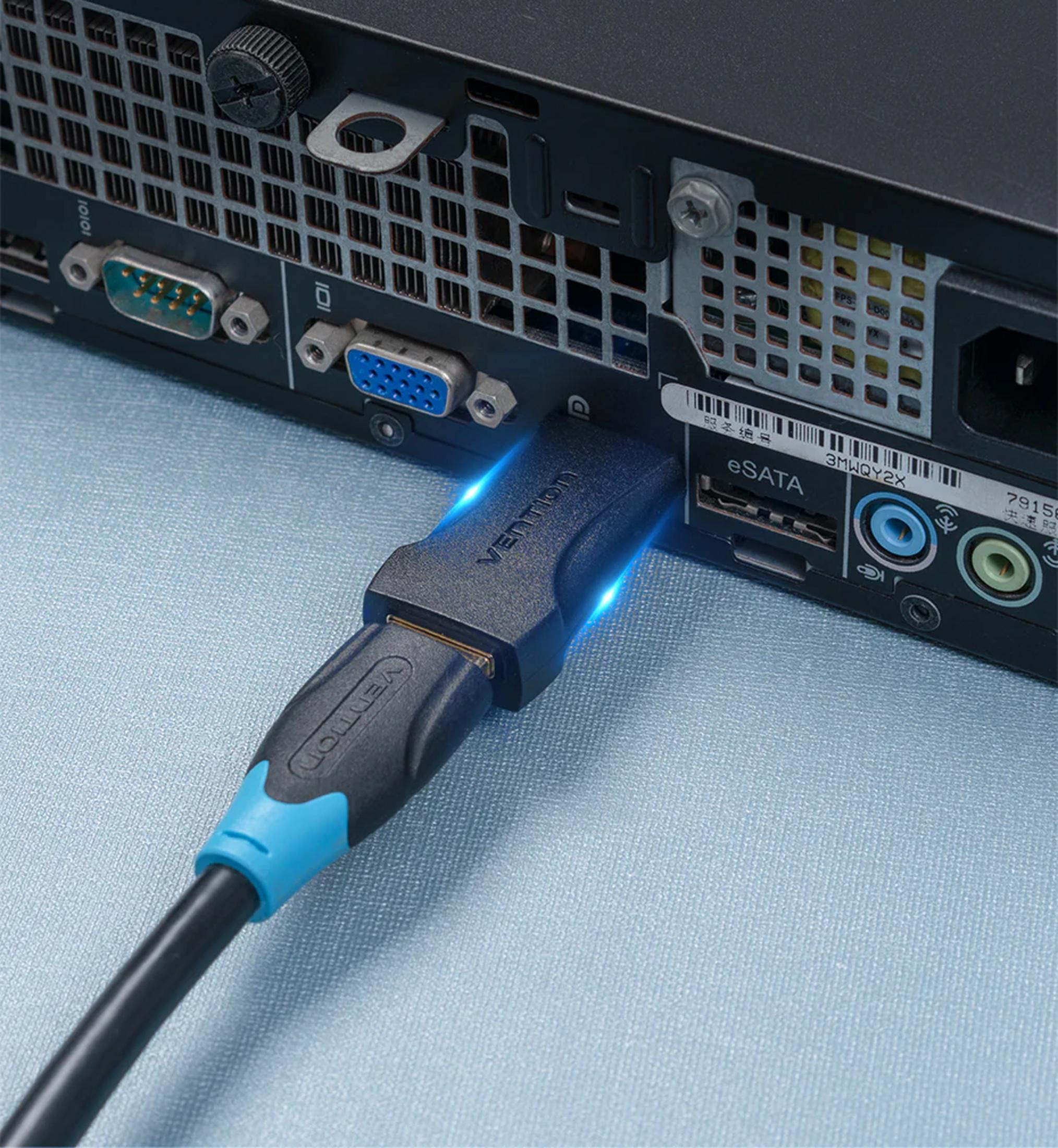 Un cable negro con un adaptador Vention está conectado a la parte trasera de un ordenador.