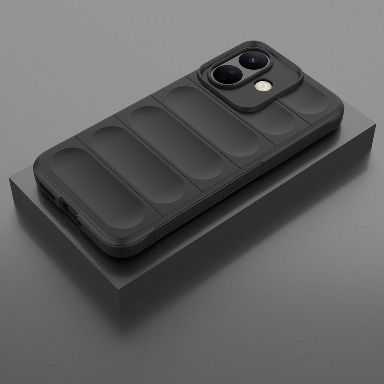 Un smartphone noir avec des nervures à l'arrière et un double appareil photo surélevé repose sur un socle gris.