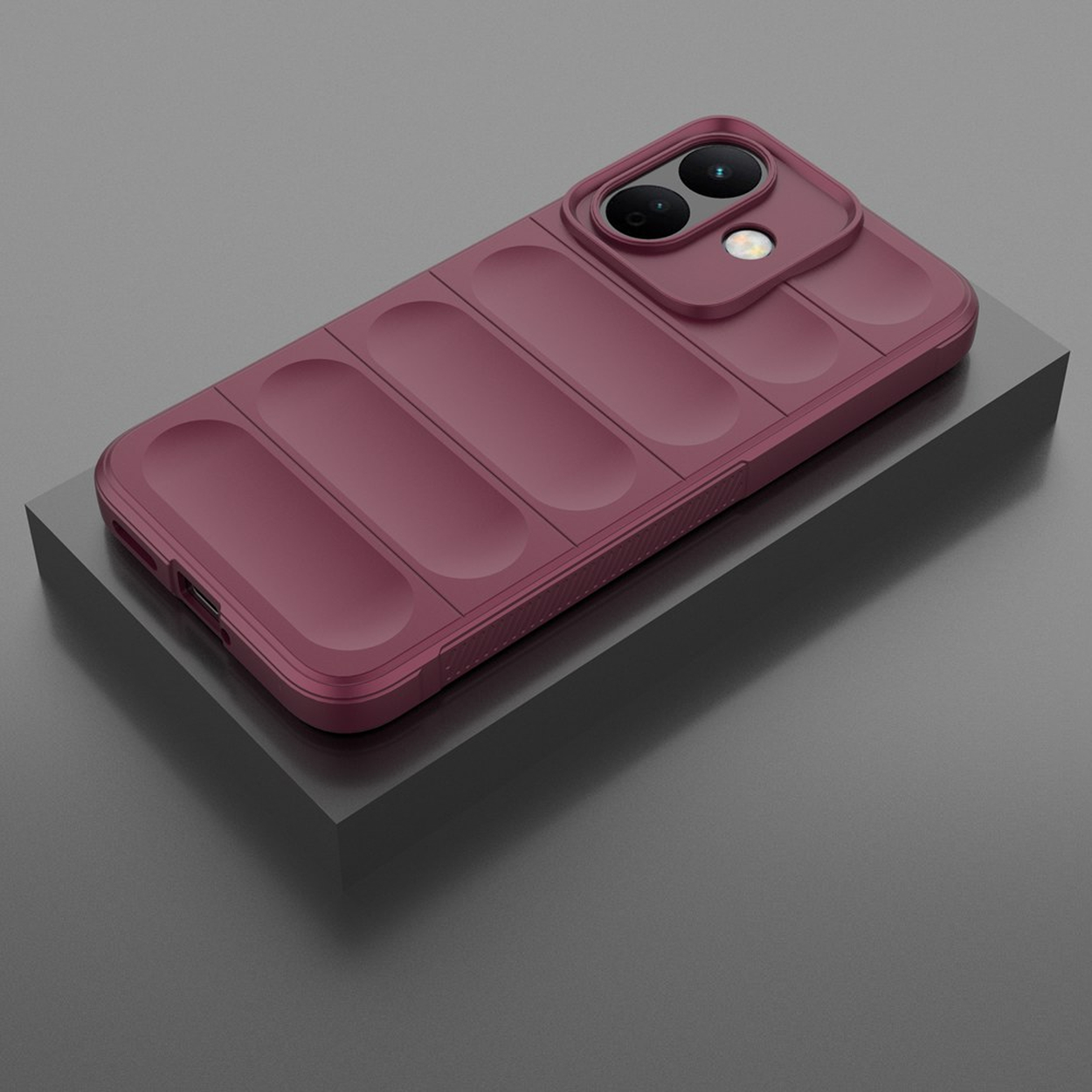 Un smartphone bordeaux à l'arrière matelassé repose sur un bloc gris.