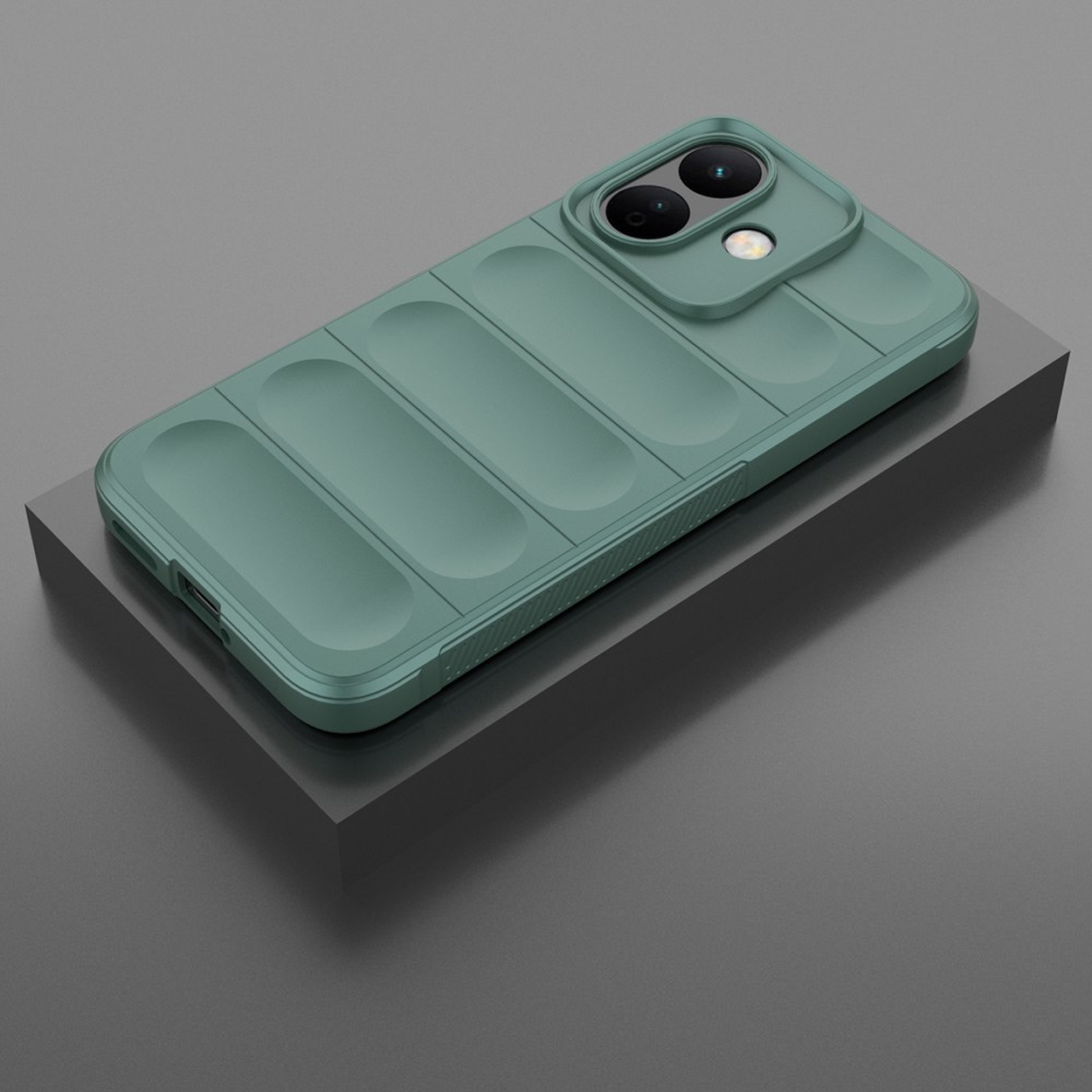 Un smartphone vert sauge dans une coque rembourrée repose en diagonale sur une plateforme gris foncé.