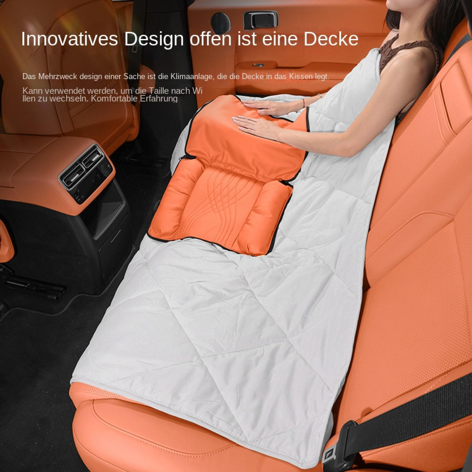 Eine Frau sitzt auf einem orangen Autositz und nutzt eine Kissen-Decken-Kombination.