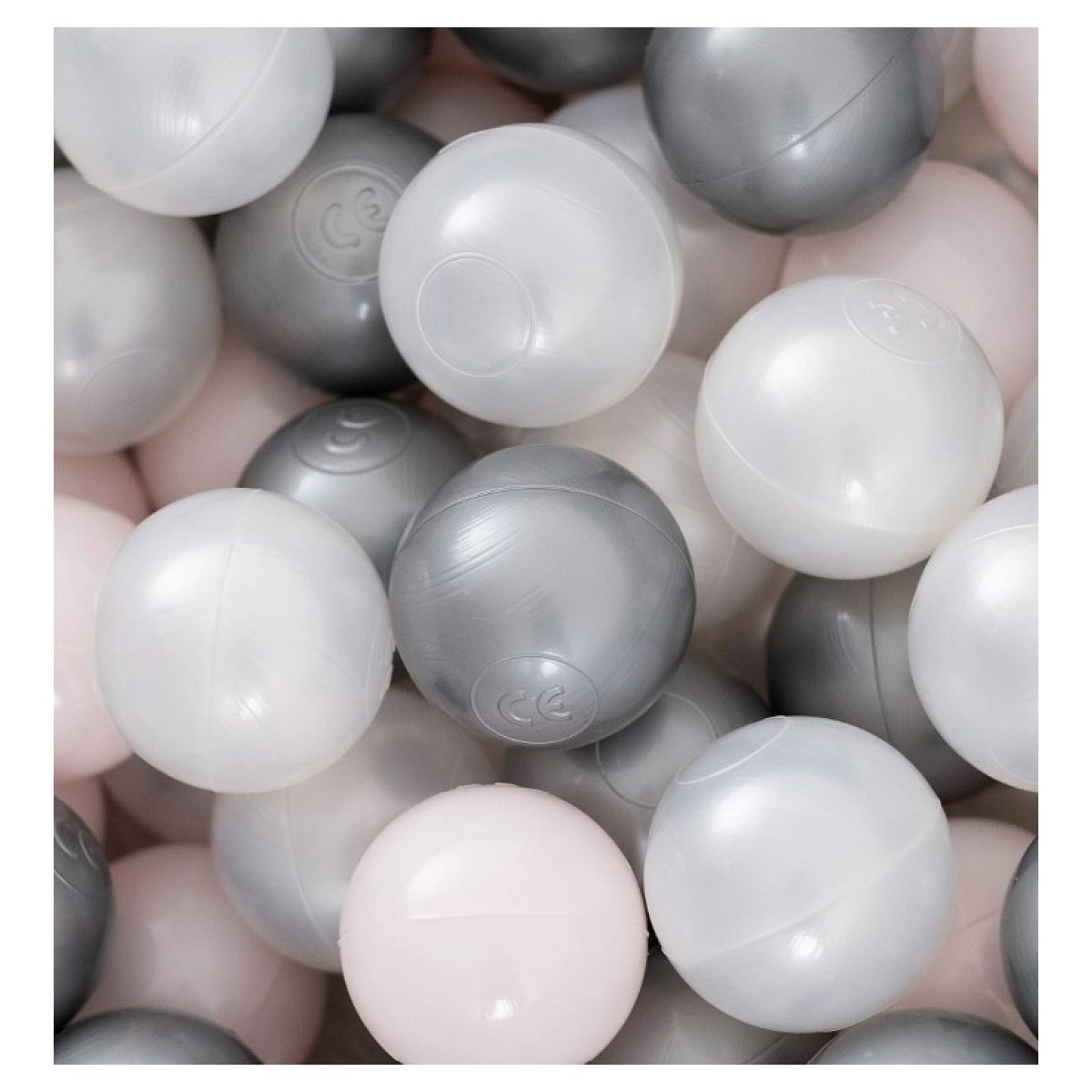 Eine Nahaufnahme von vielen glänzenden, runden Plastikbällen in den Farben Weiß, Grau und zartem Rosa.