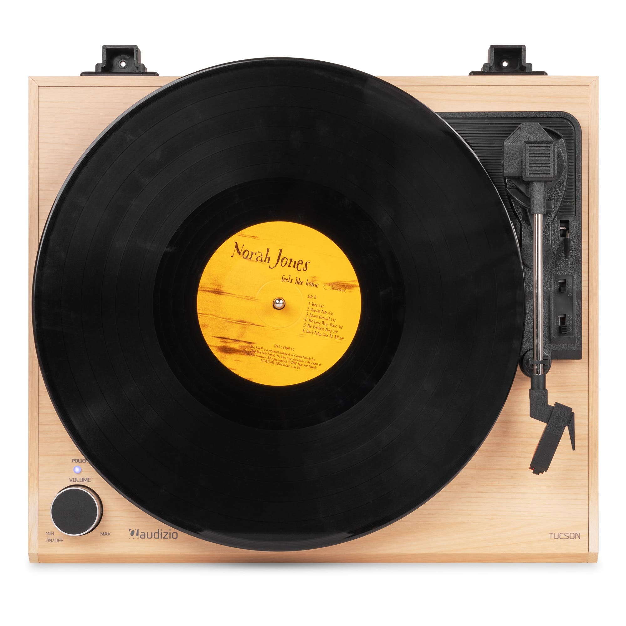 Ein holzfarbener Plattenspieler mit einer schwarzen Vinylplatte und einem gelben Plattenlabel von Norah Jones.