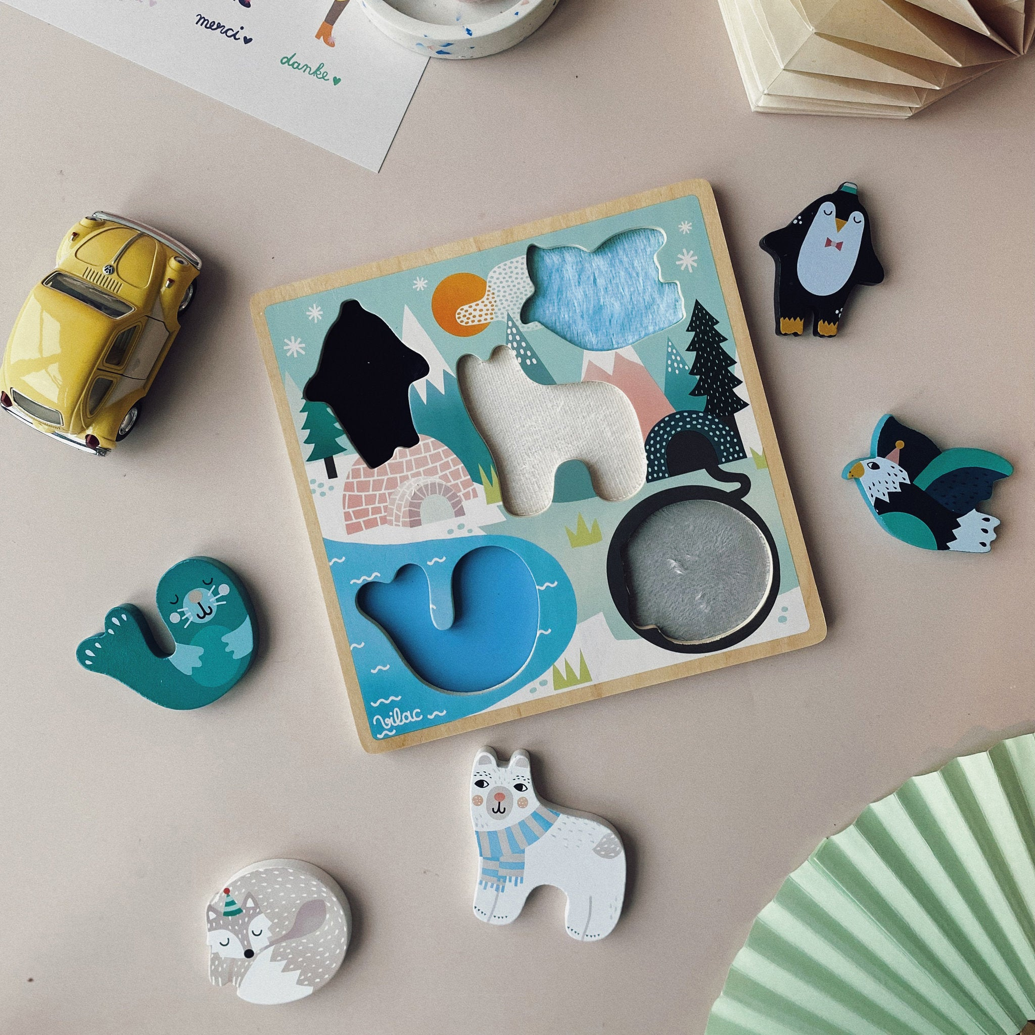 Ein Holz-Ausschnitt-Puzzle mit arktischen Motiven und verschiedenen Tierfiguren wie Robbe, Bär und Pinguin.