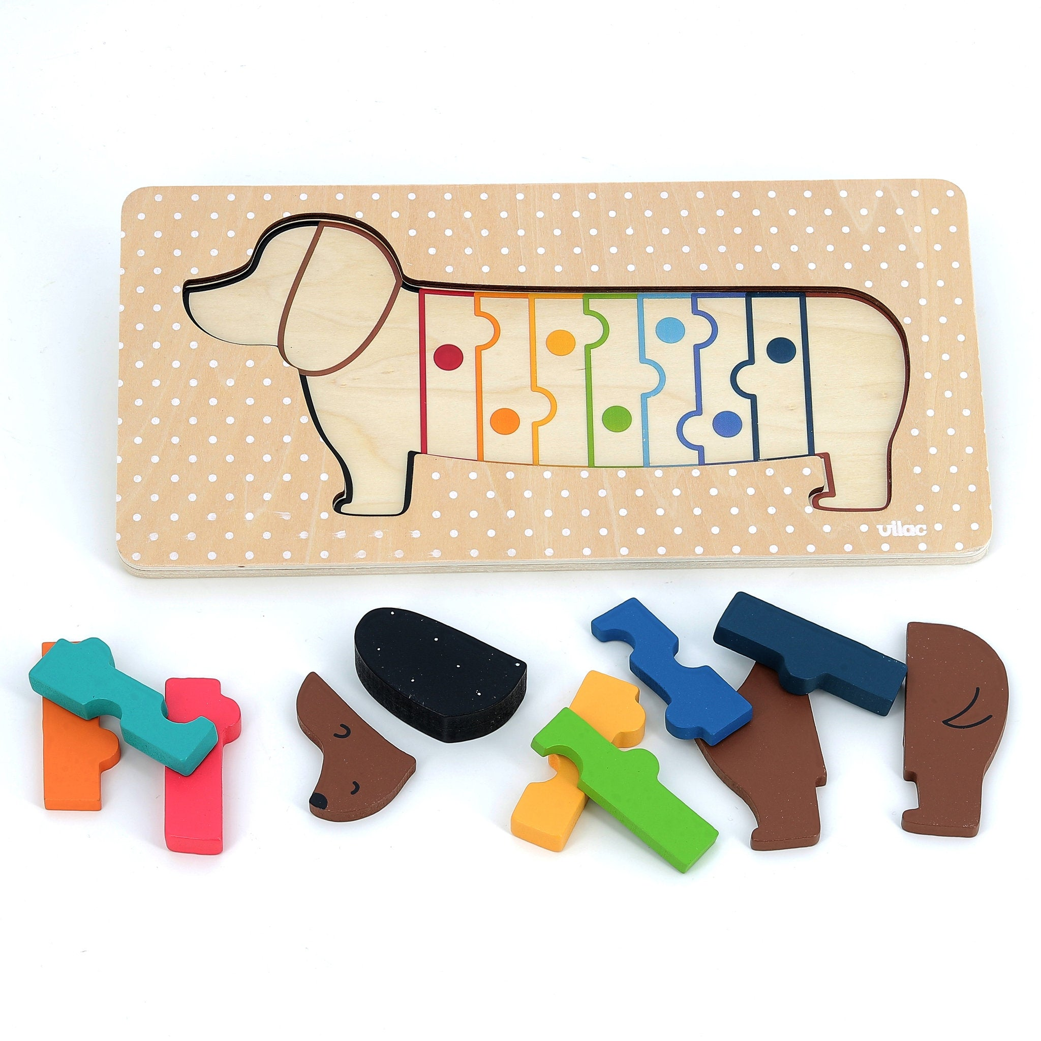 Ein Holzpuzzle mit einem Dackel und bunten Puzzleteilen davor.