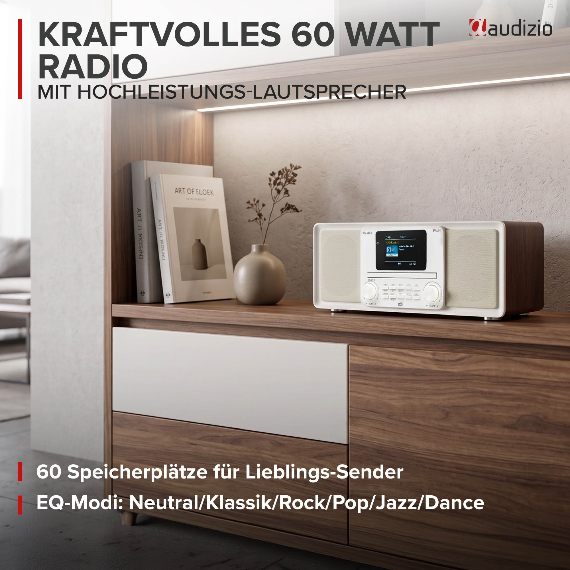 Ein weißes Radio mit Holzrahmen steht auf einem Sideboard neben Büchern und einer Vase mit Zweigen.