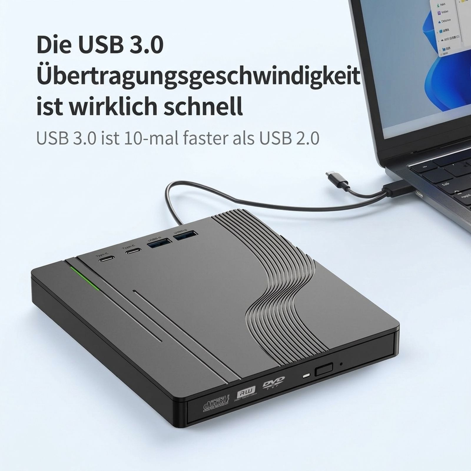 Graues externes DVD-Laufwerk mit USB-Anschluss neben einem Laptop auf weißem Tisch.