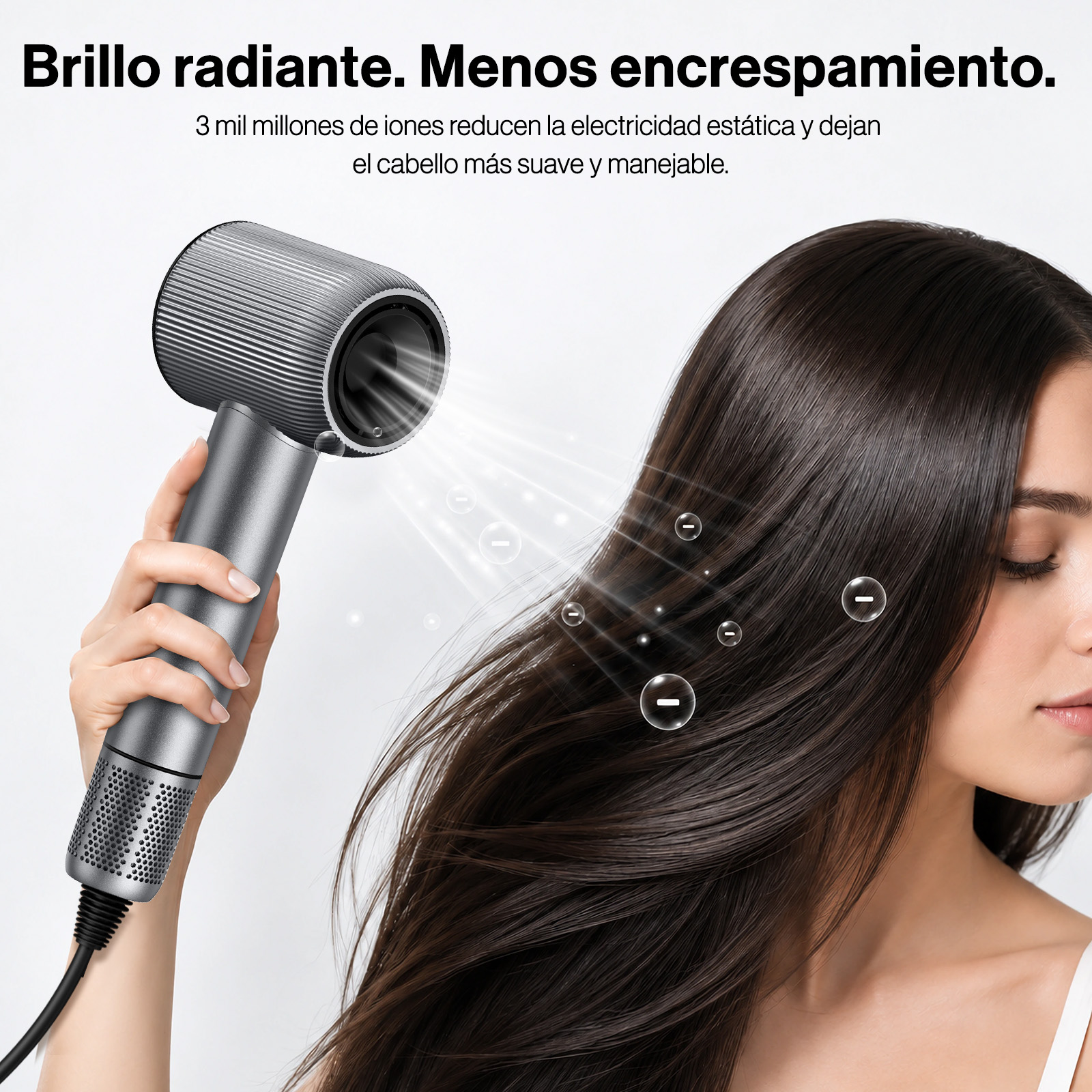 Una mujer sostiene un secador gris moderno, soplando Iones en su cabello brillante.