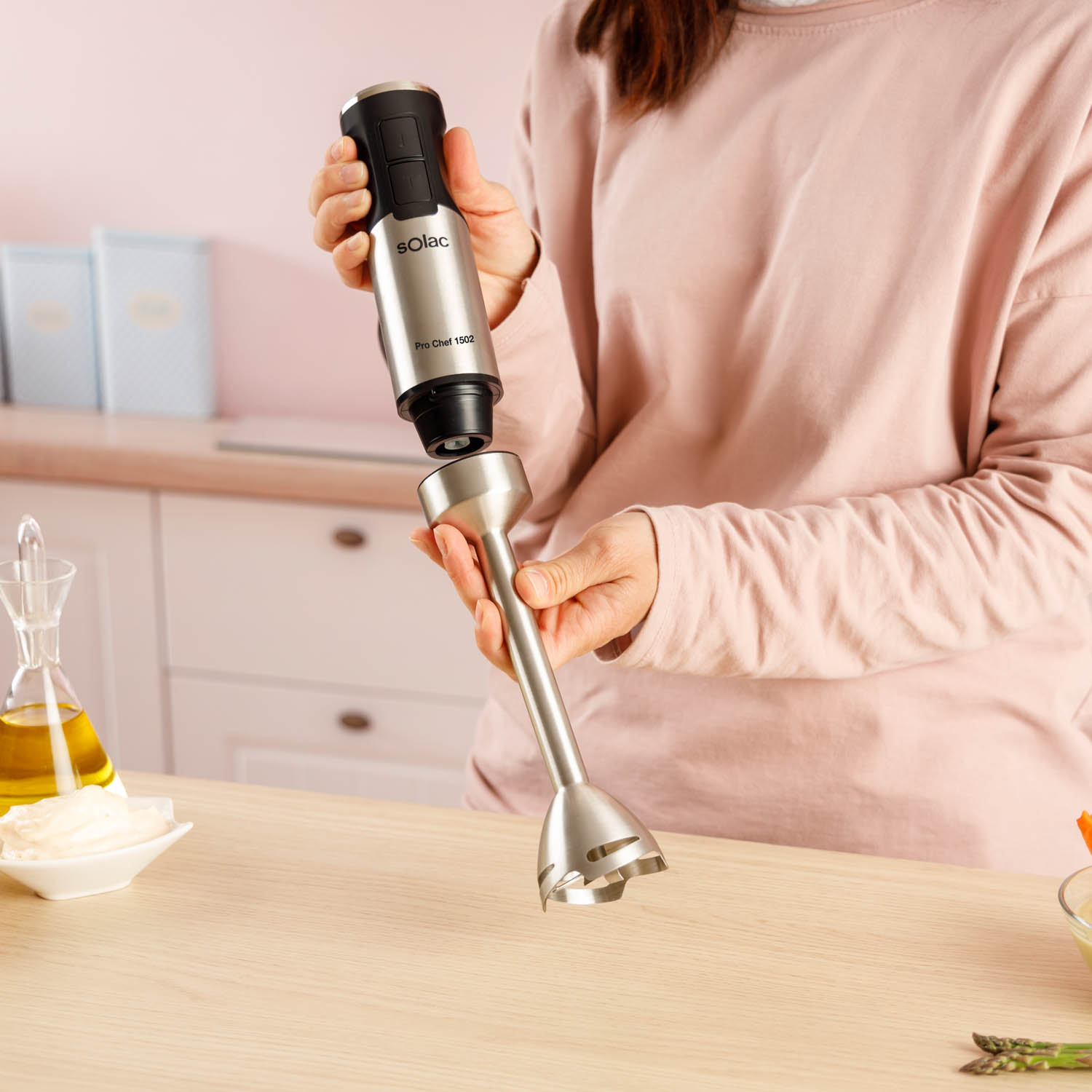 Kobieta w różu składa blender ręczny Solac Pro Chef 1502 w kuchni.